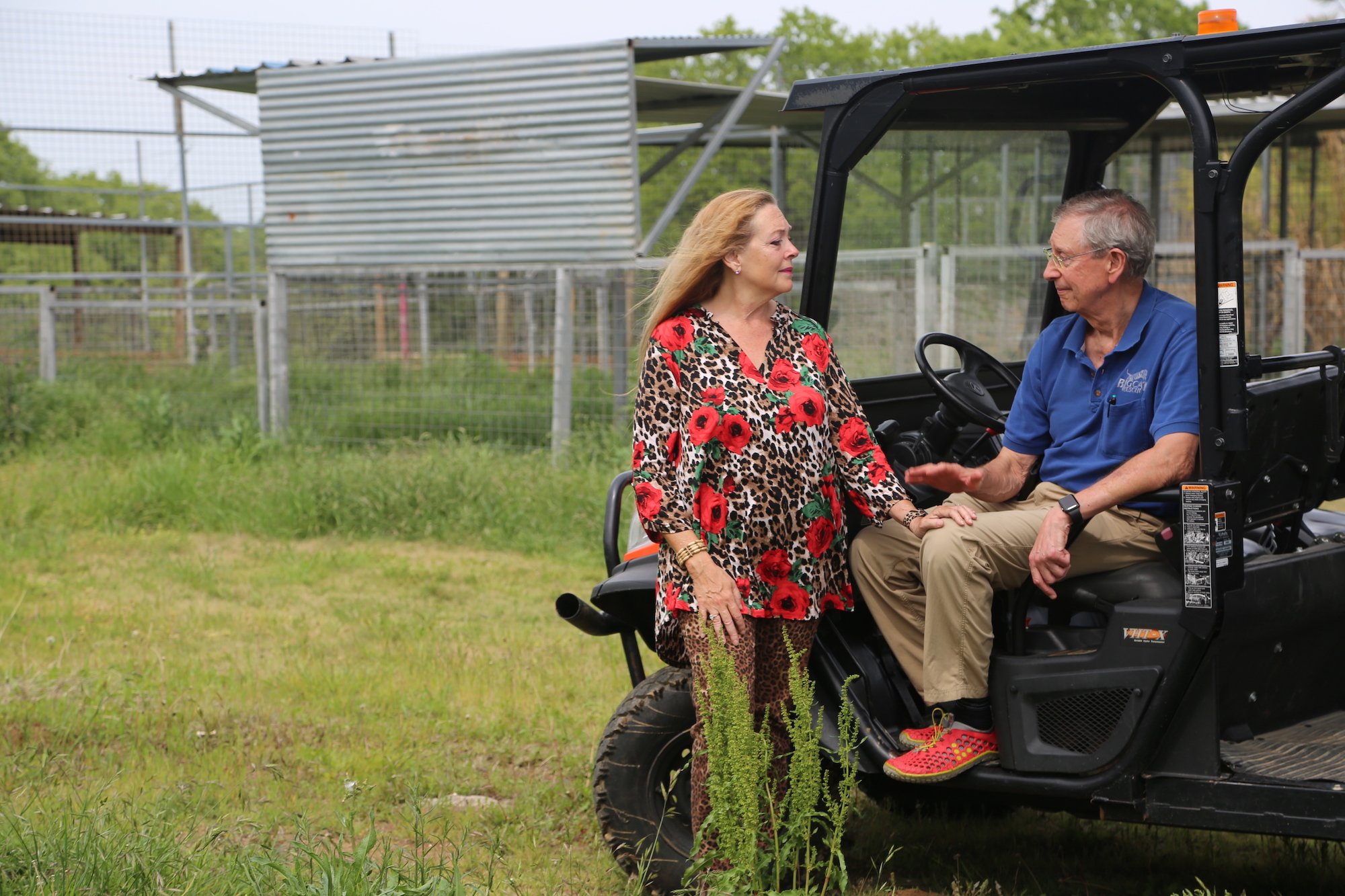 In GW Zoo, Carole Baskin puts her hand on Howard Baskin's knee as he sits on a tractor