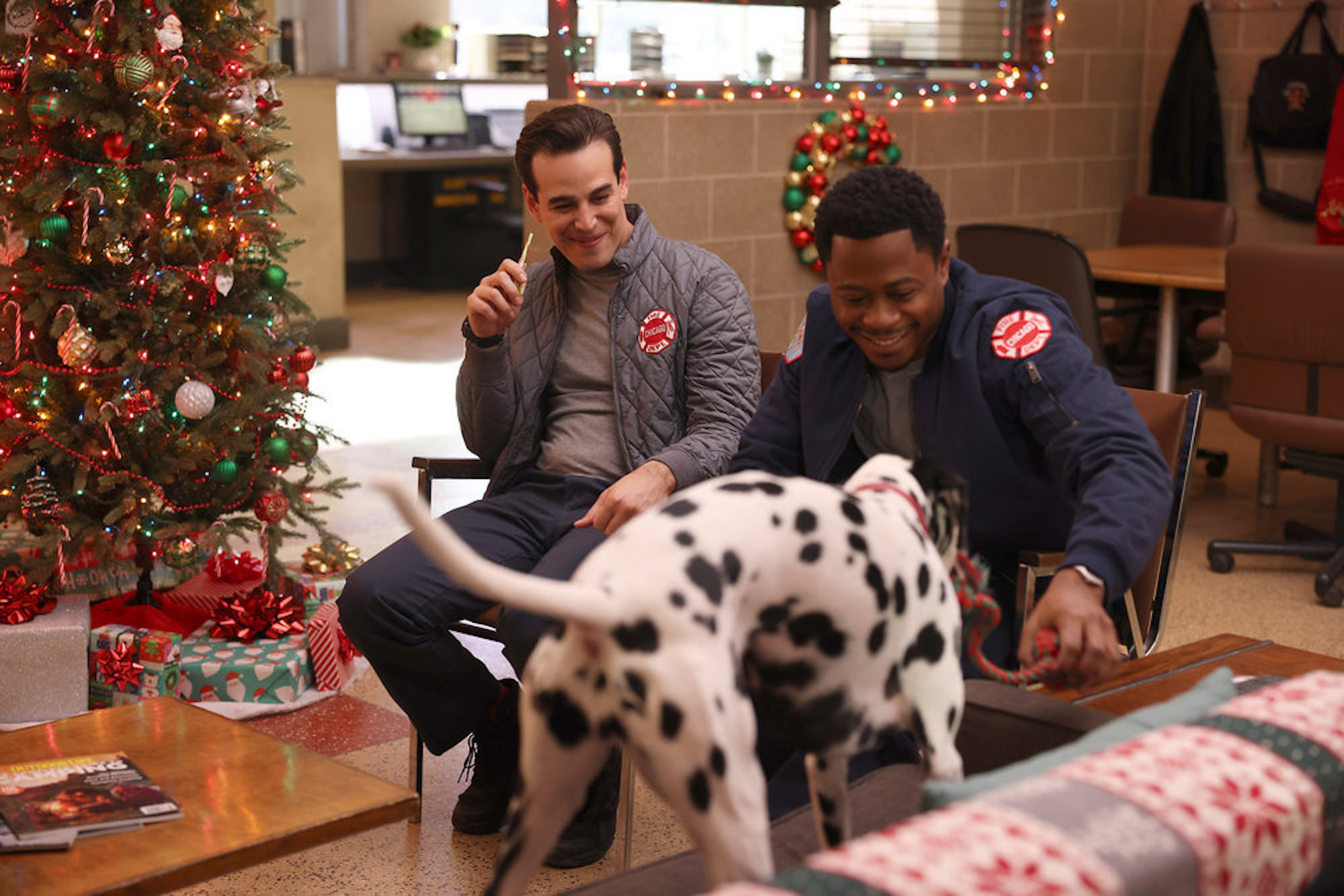 Blake Gallo and Darren Ritter smiling and petting a Dalmatian in 'Chicago Fire' Season 10 Episode 9
