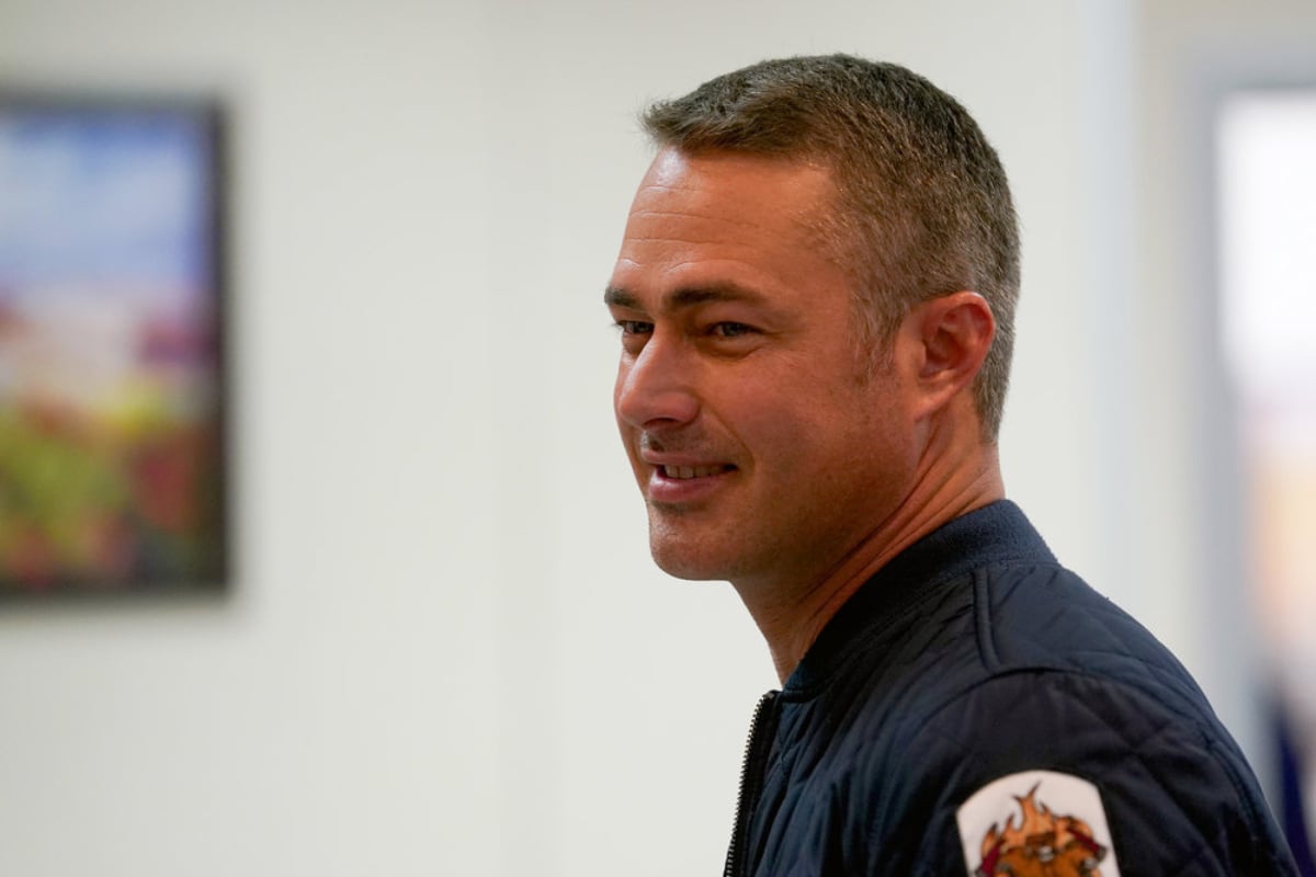 Taylor Kinney as Kelly Severide in Chicago Fire Season 10. Severide is smiling.