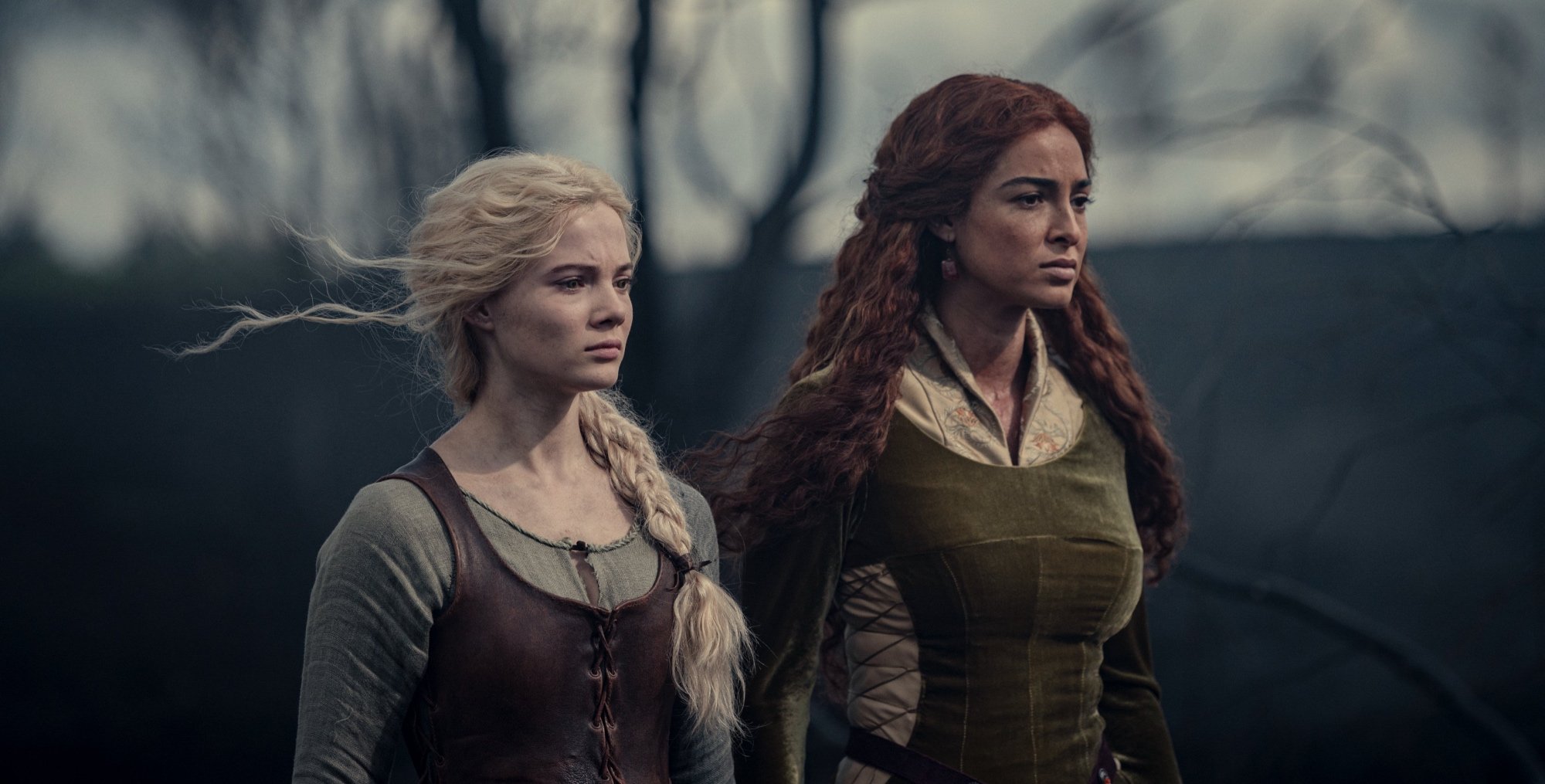 Ciri and Triss in 'The Witcher' Season 2 in the forest looking forward.