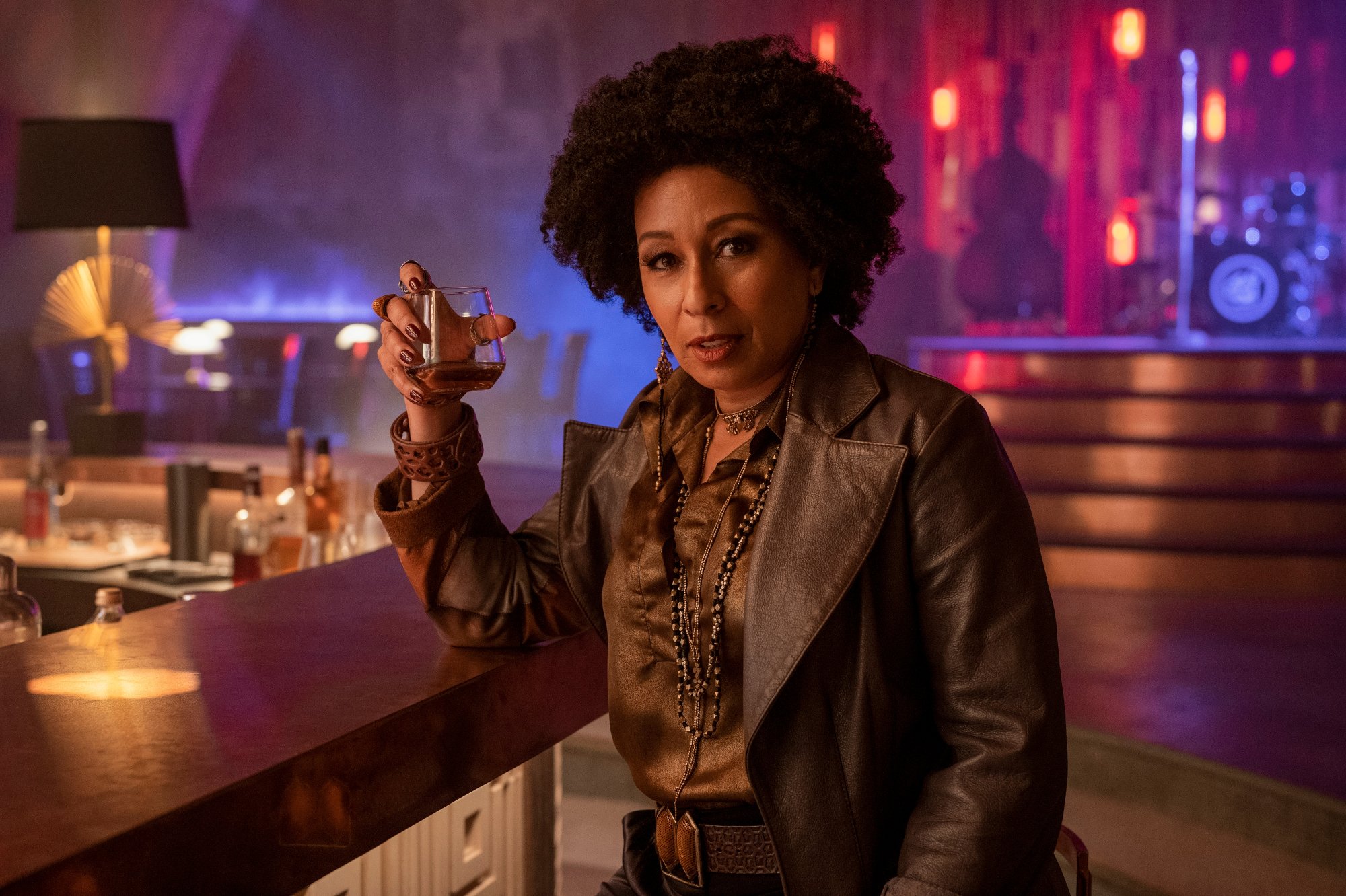Tamara Tunie as Ana in Netflix's live-action 'Cowboy Bebop.' She's sitting at a bar and holding a glass.