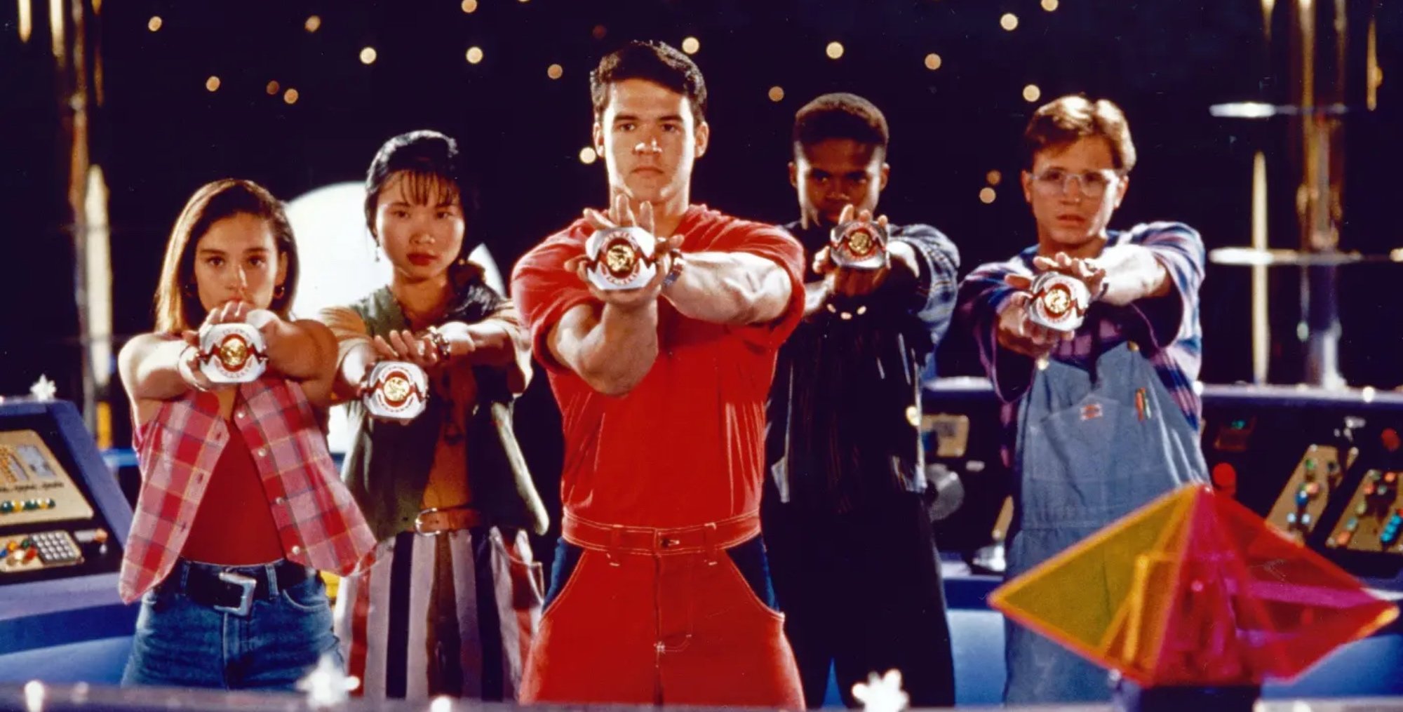 David Yost and the cast of 'Mighty Morphin Power Rangers' holding out Morphers in command center.