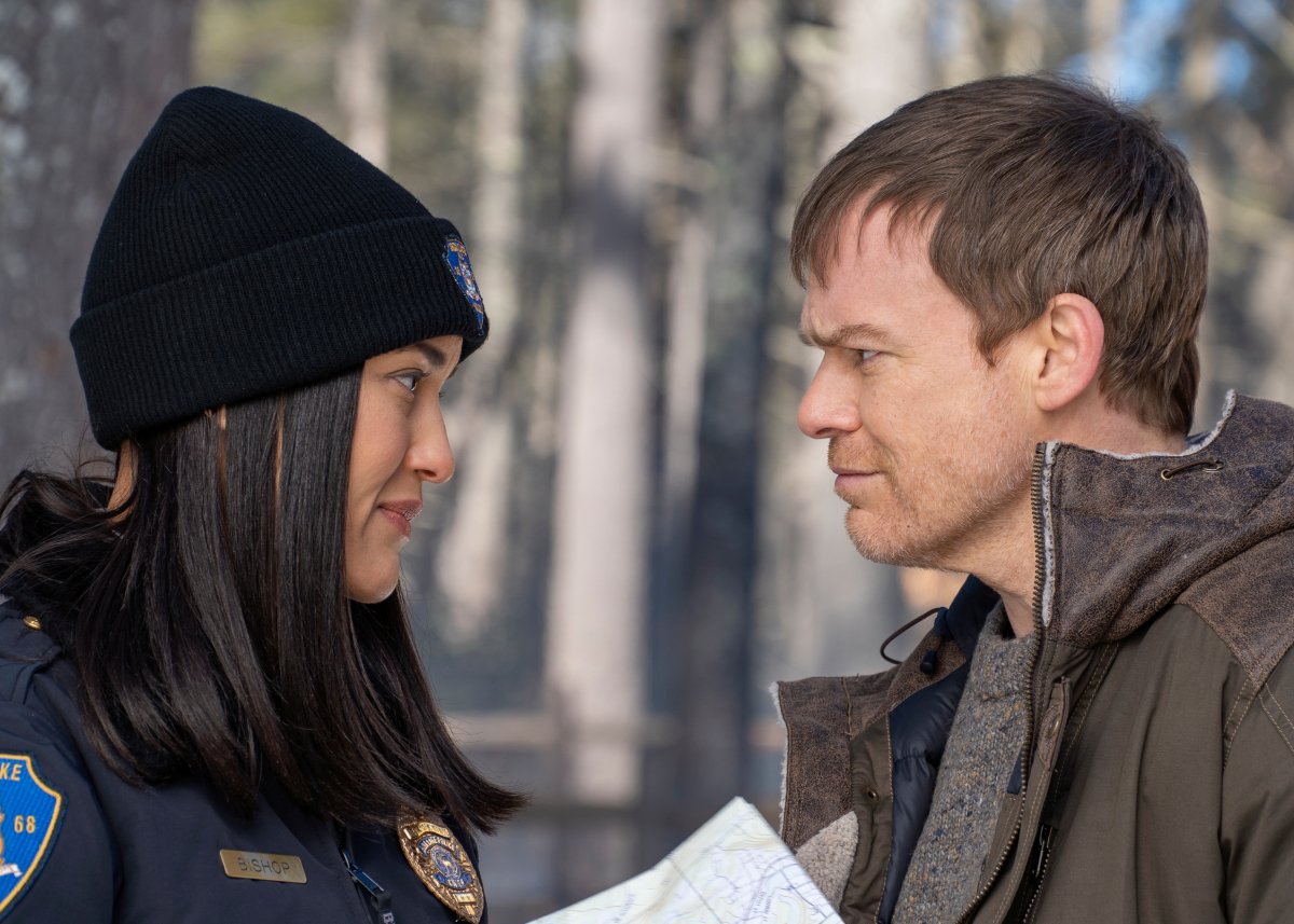 Julia Jones as Angela and Michael C. Hall as Dexter in Dexter: New Blood. Angela and Dexter face each other in the woods.