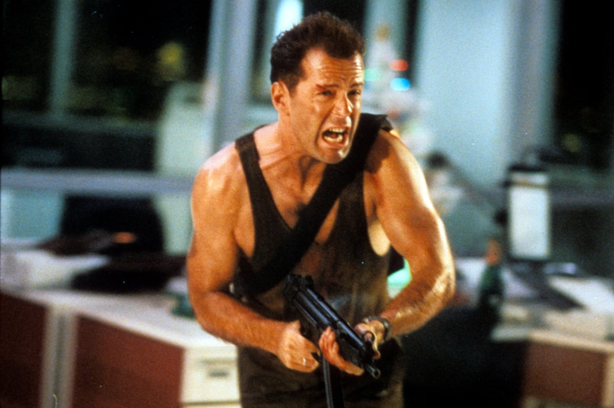 Bruce Willis running with an automatic weapon in a scene from the movie 'Die Hard', 1988