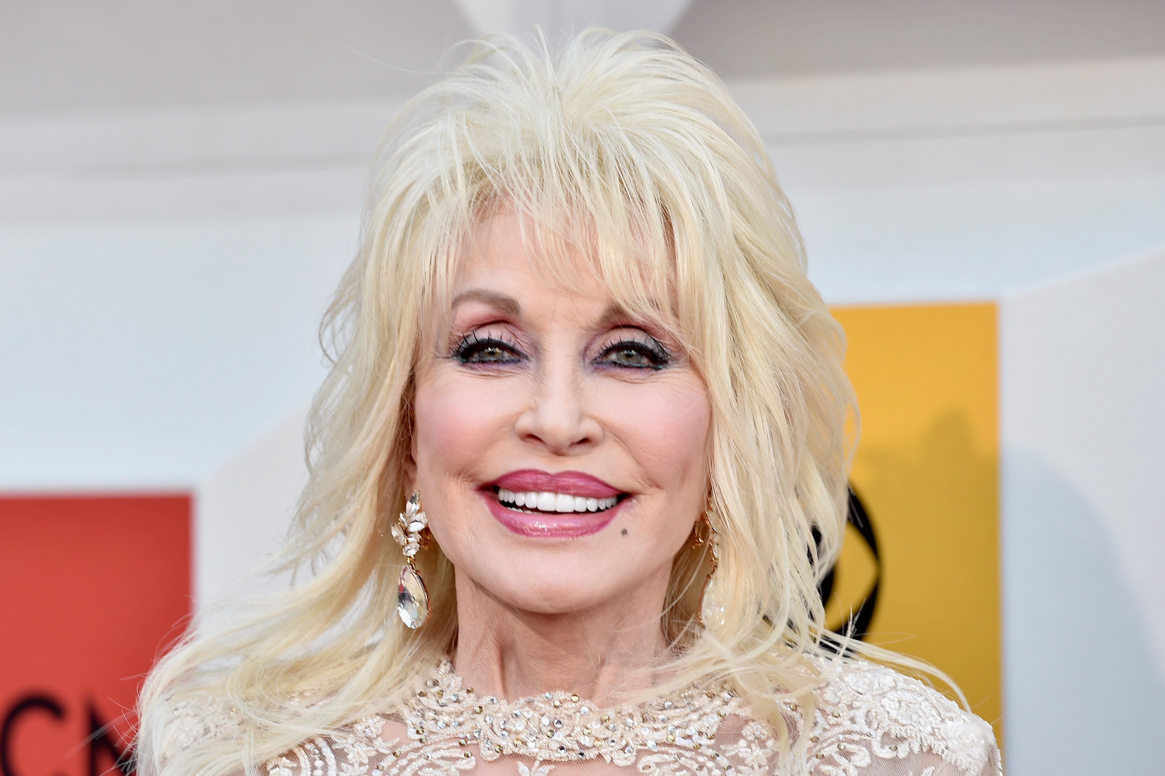 Dolly Parton wears a white lace top.