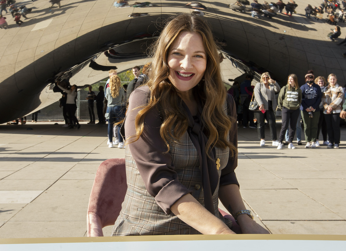 Drew Barrymore smiling in front of 'The Bean' in Chicago