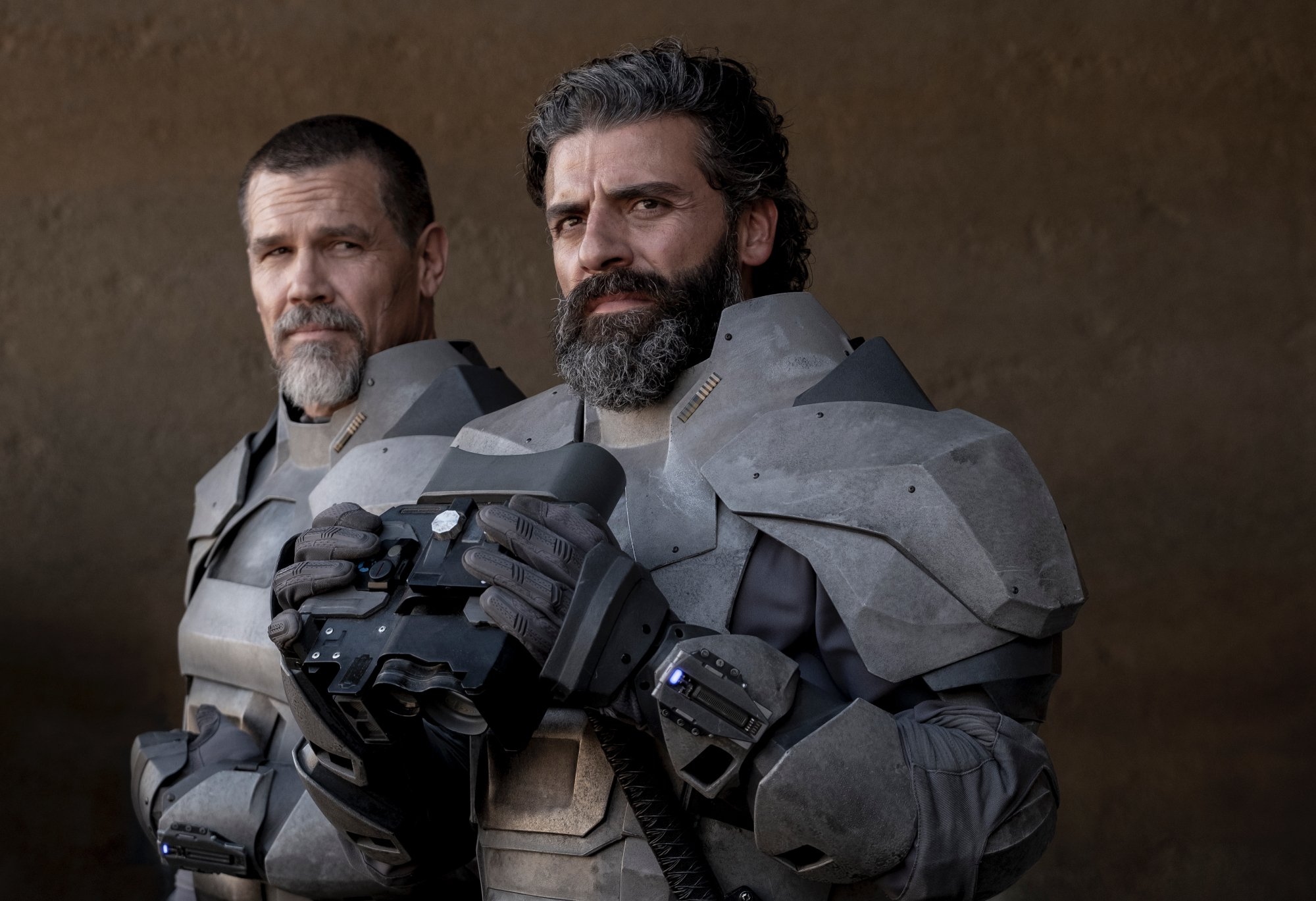 'Dune' Josh Brolin as Gurney Halleck and Oscar Isaac as Duke Leto Atreides standing in gear holding binoculars