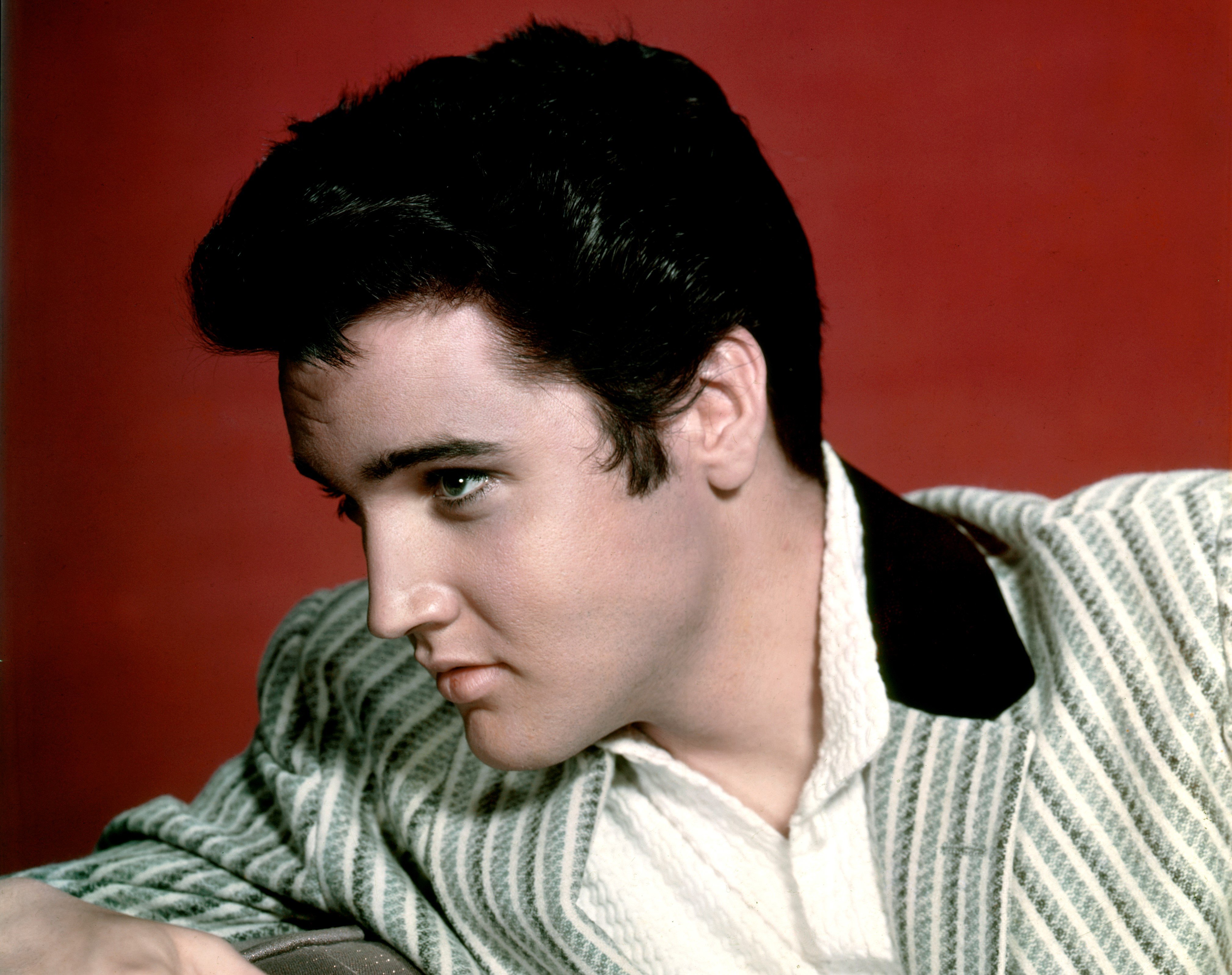 Elvis Presley, who many believe makes a cameo in the holiday movie 'Home Alone,' wears a green and white striped suit jacket over a white button-up shirt.