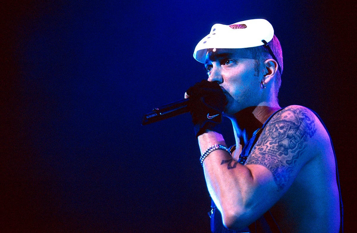Eminem wearing a hockey mask holding a microphone.