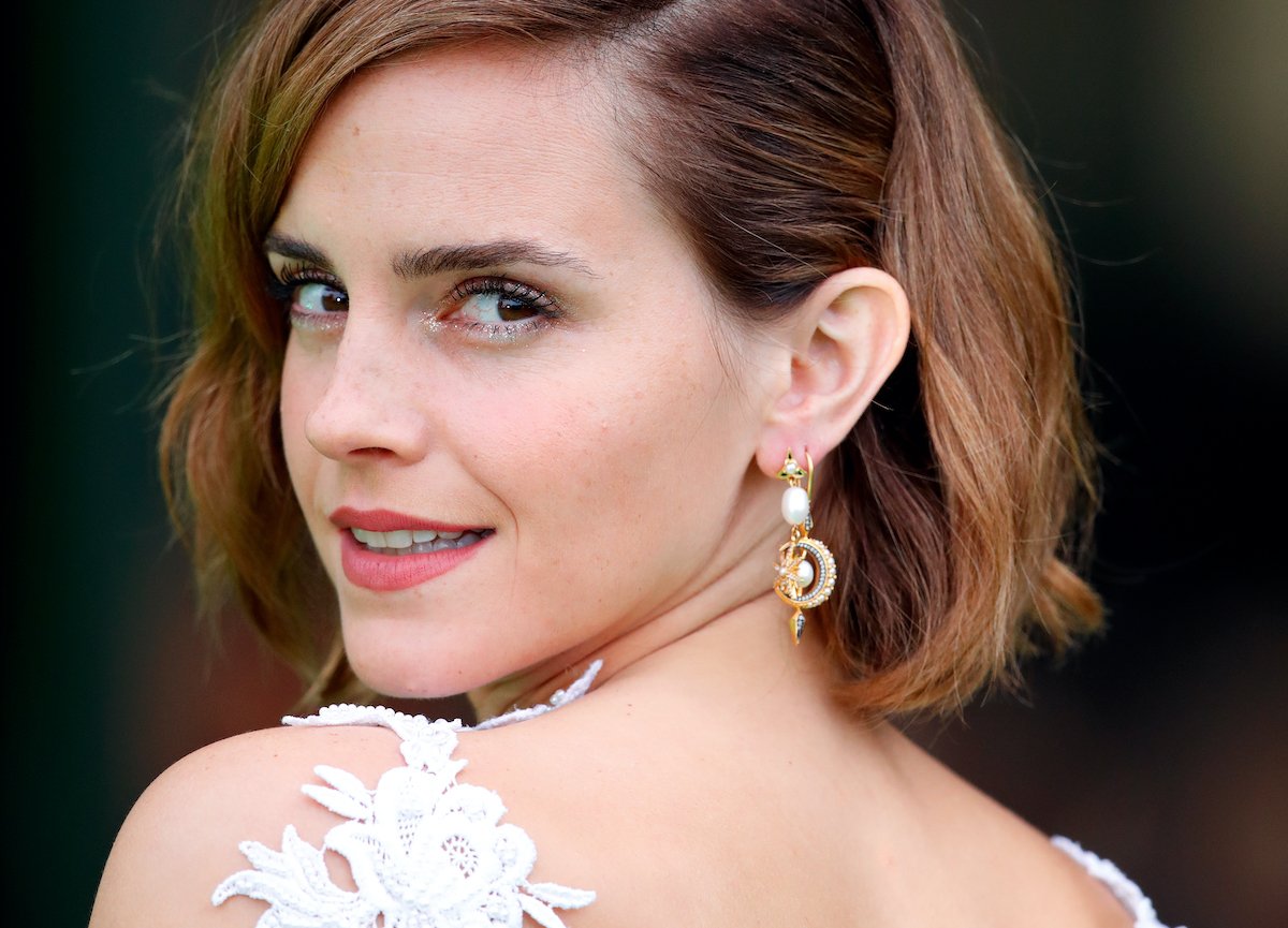 Emma Watson glances over her shoulder in a white dress