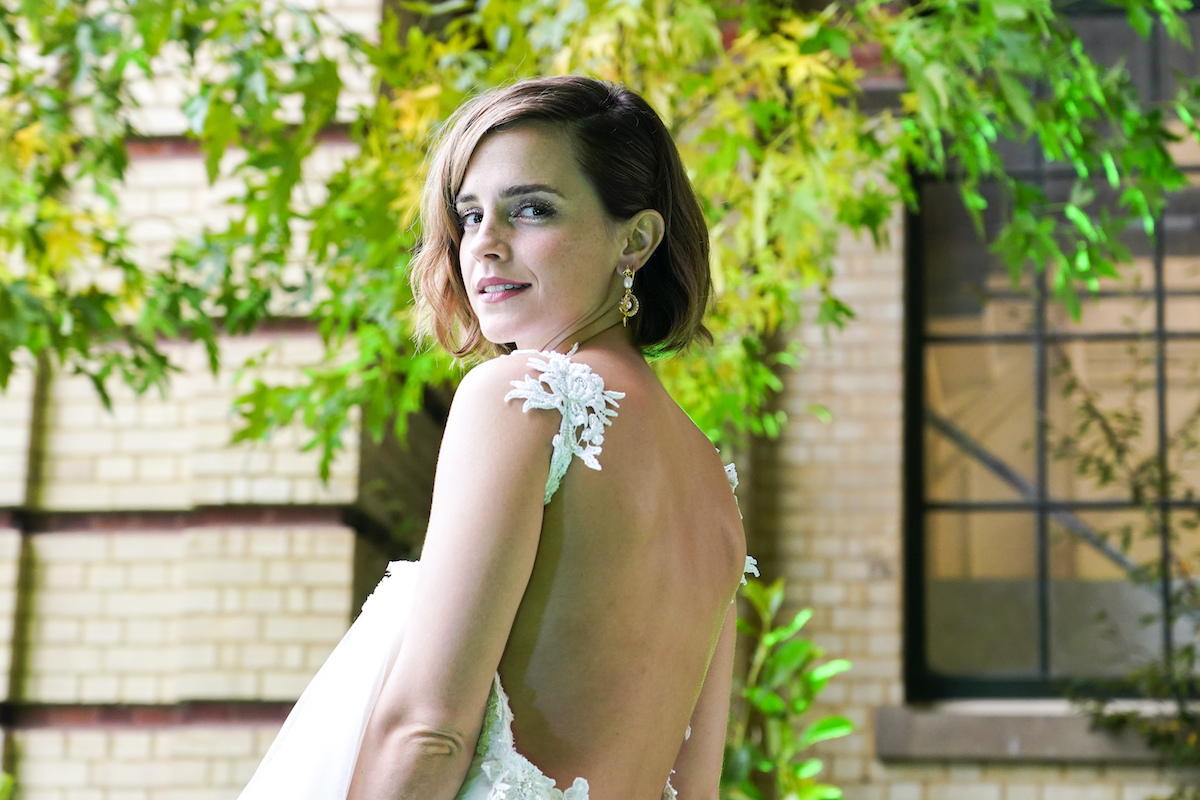Emma Watson looks over her shoulder in a backless white dress
