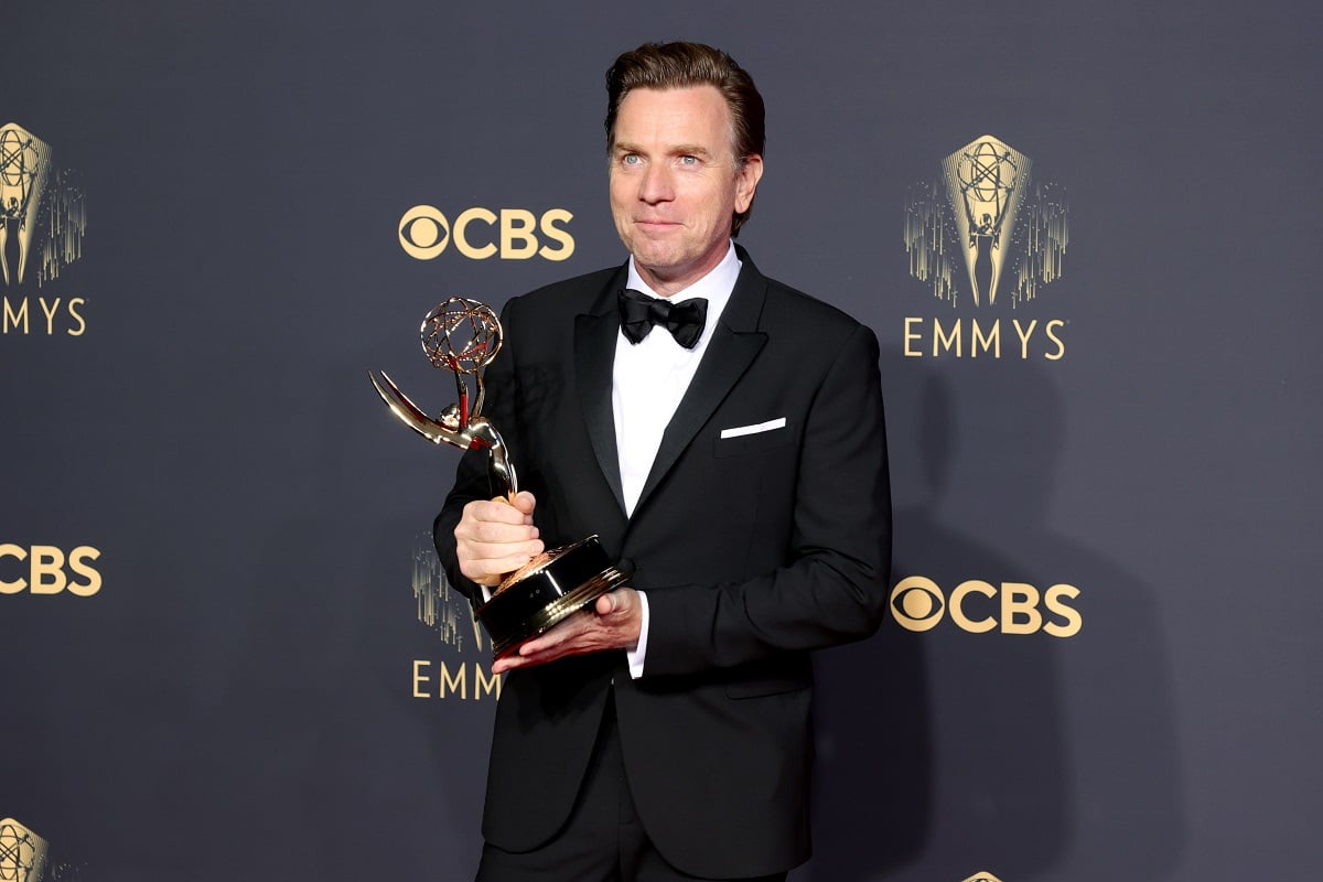 Ewan McGregor holding an Emmy award.