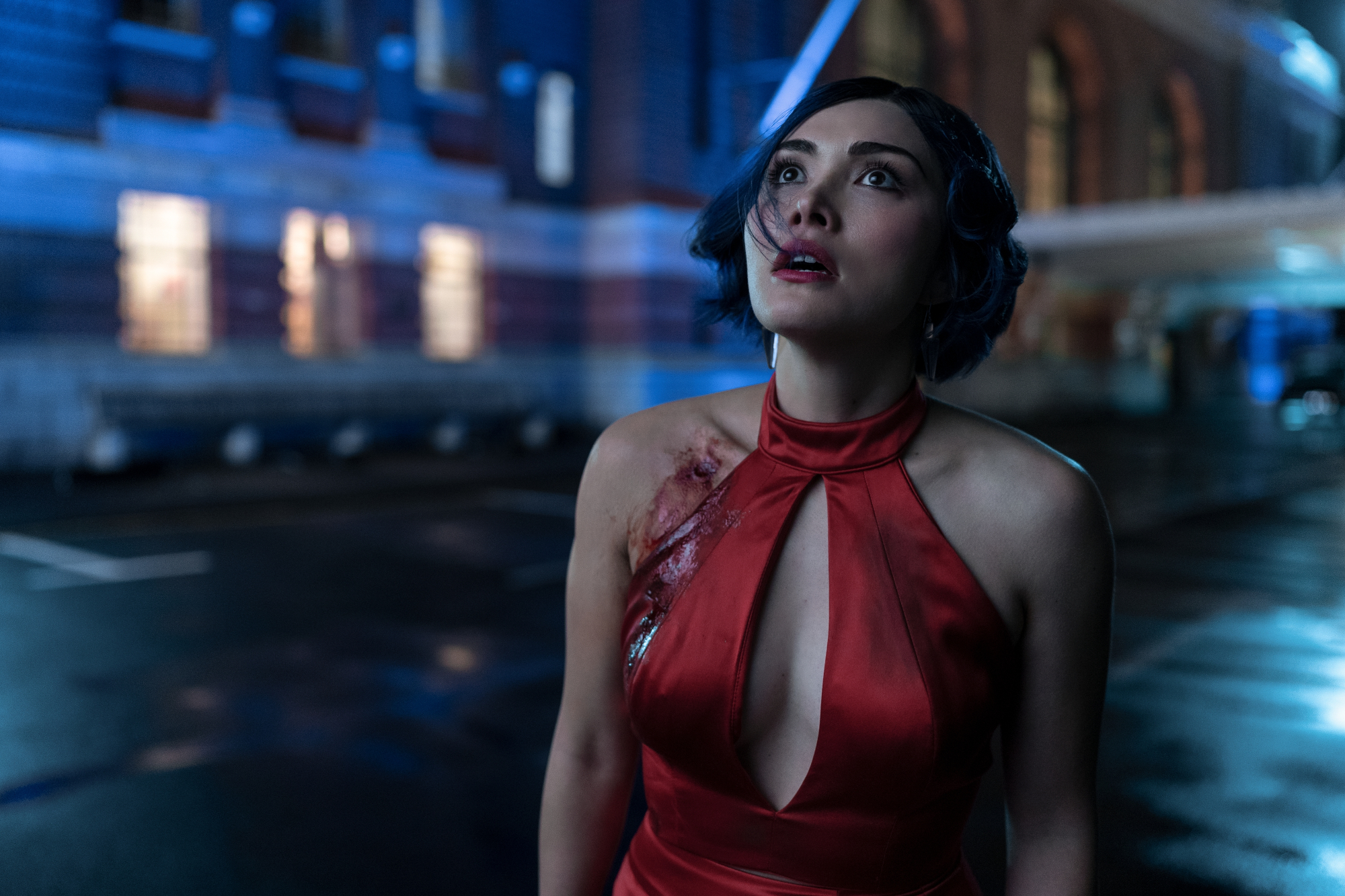 Daniella Pineda as Faye Valentine in Netflix's live-action 'Cowboy Bebop.' She's wearing a red top and looking up. Her right shoulder has blood on it.