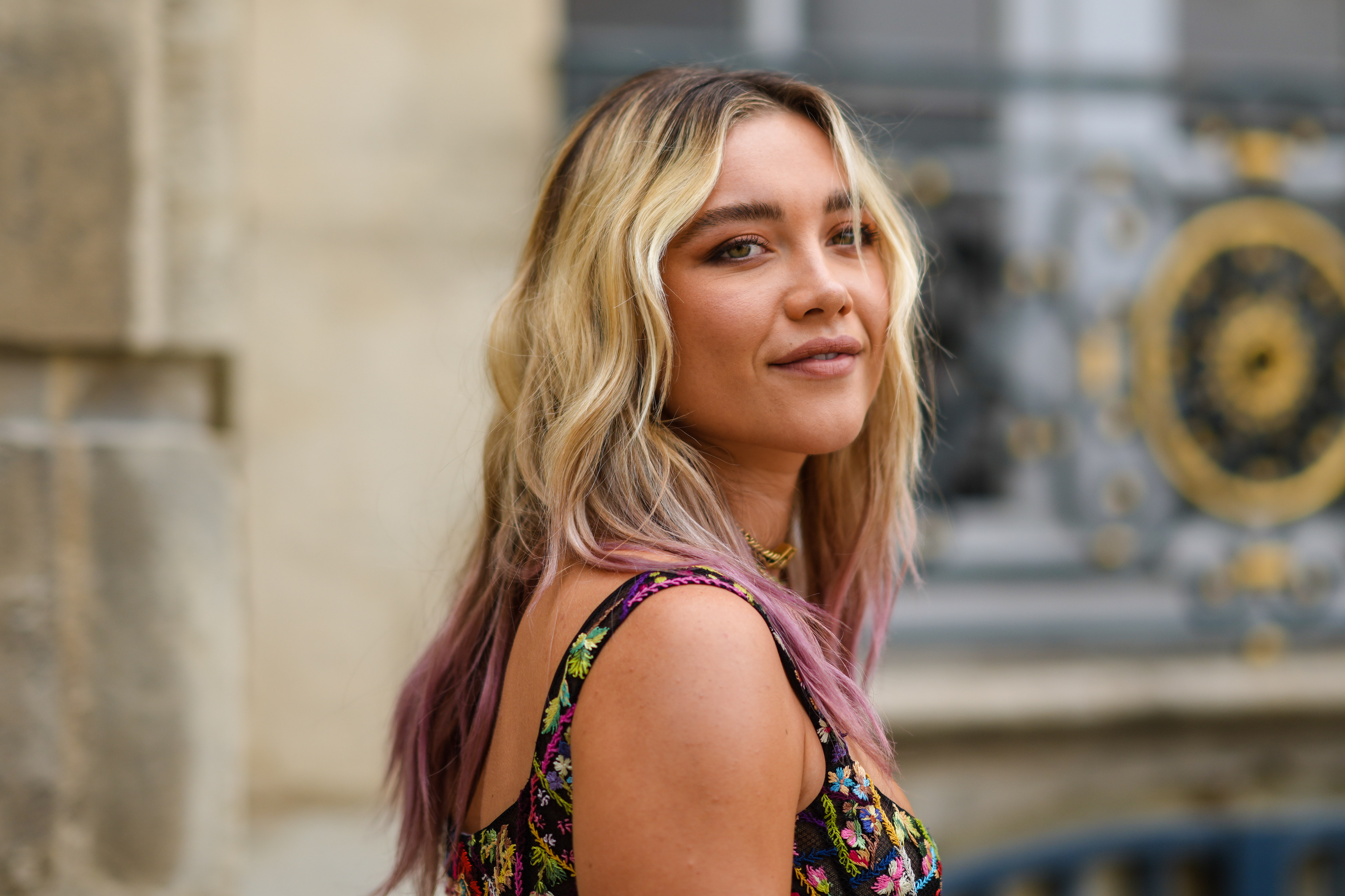 'Hawkeye' star Florence Pugh, who plays Yelena Belova in the show, wears a multi-colored floral tank top. Her hair is dyed purple at the ends.