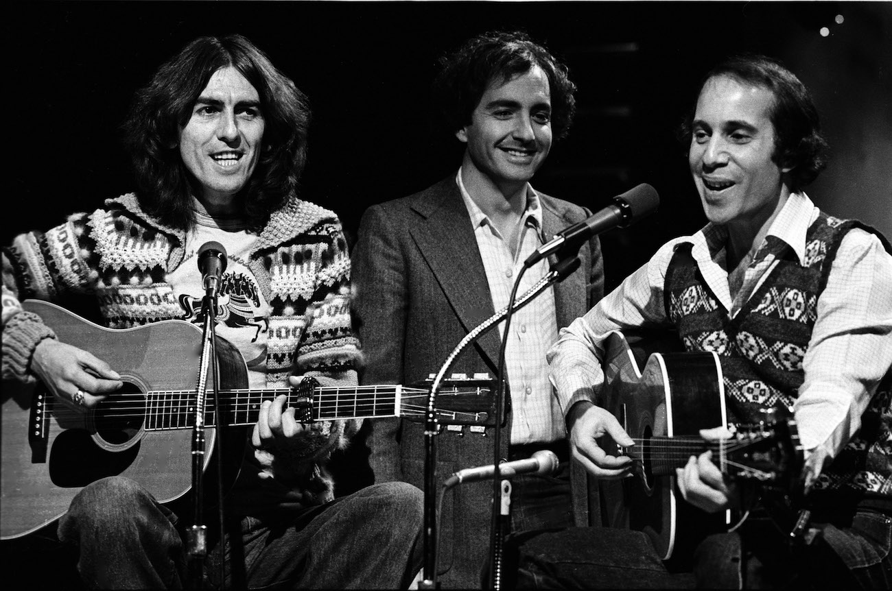 George Harrison, Lorne Michaels, and Paul Simon during a performance on 'Saturday Night Live' in 1976.