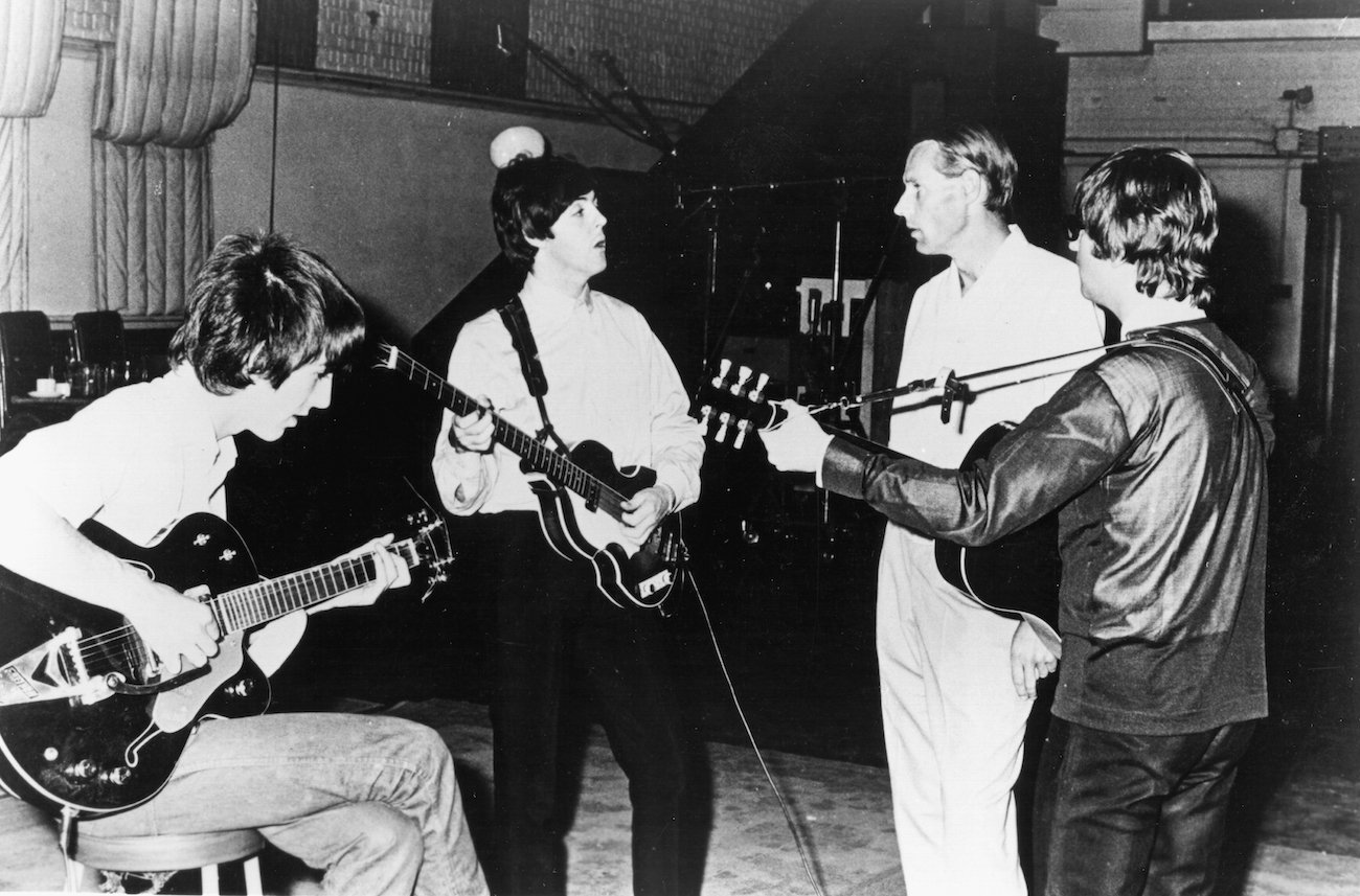 George Harrison, Paul McCartney, John Lennon, Ringo Starr, and producer George Martin working on songs in 1964.