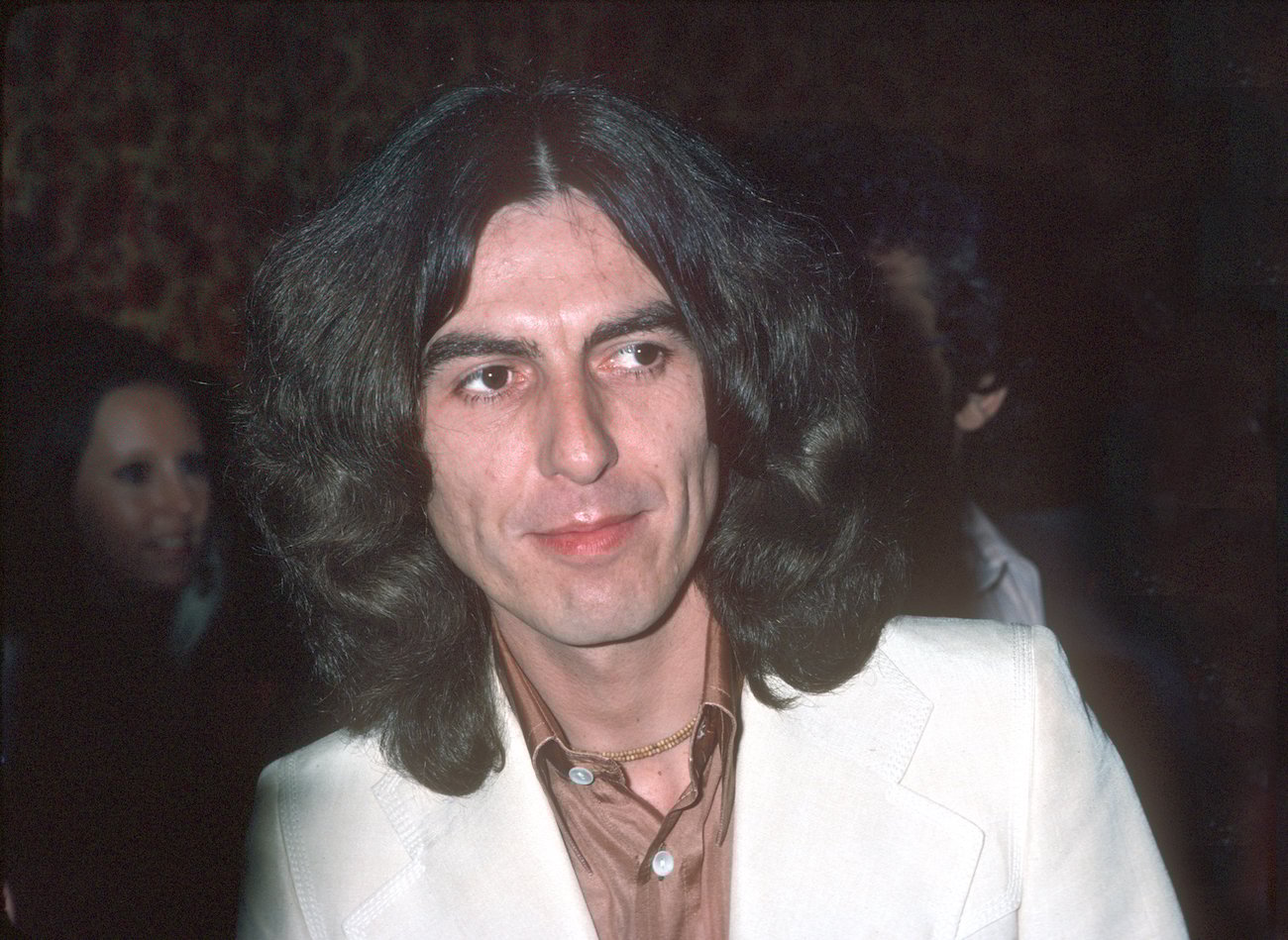 George Harrison attending an event wearing a white suit in 1978.