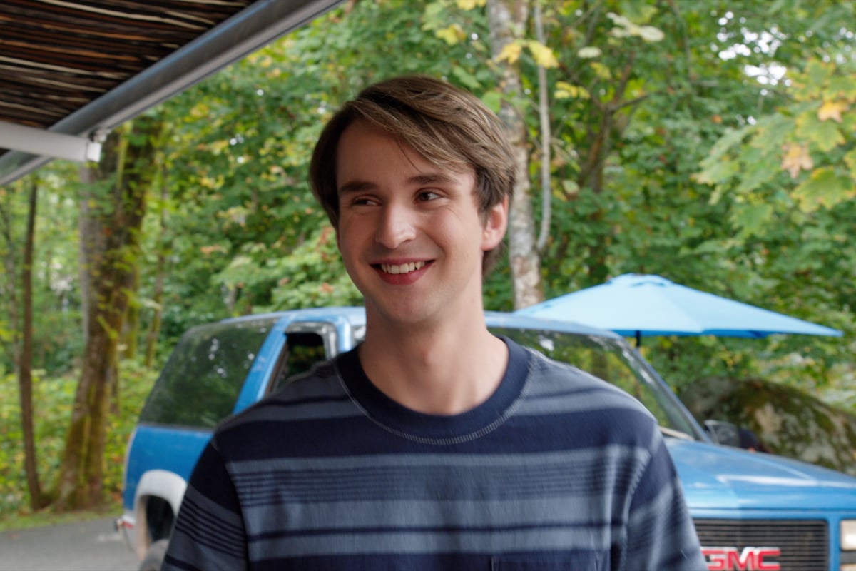 In a still from 'Virgin River,' Ricky (Grayson Gurnsey) smiling in a blue shirt on 'Virgin River