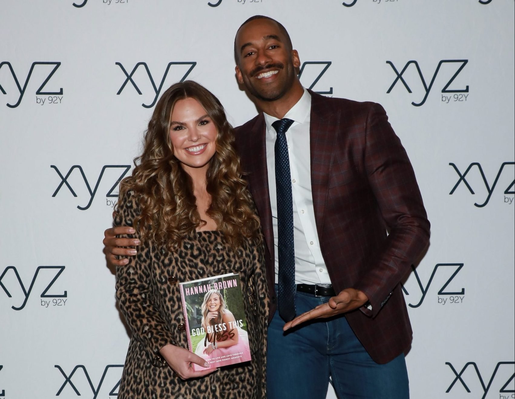 'Bachelorette' alum Hannah Brown is holding her new memoir while former 'Bachelor' Matt James points toward the book.