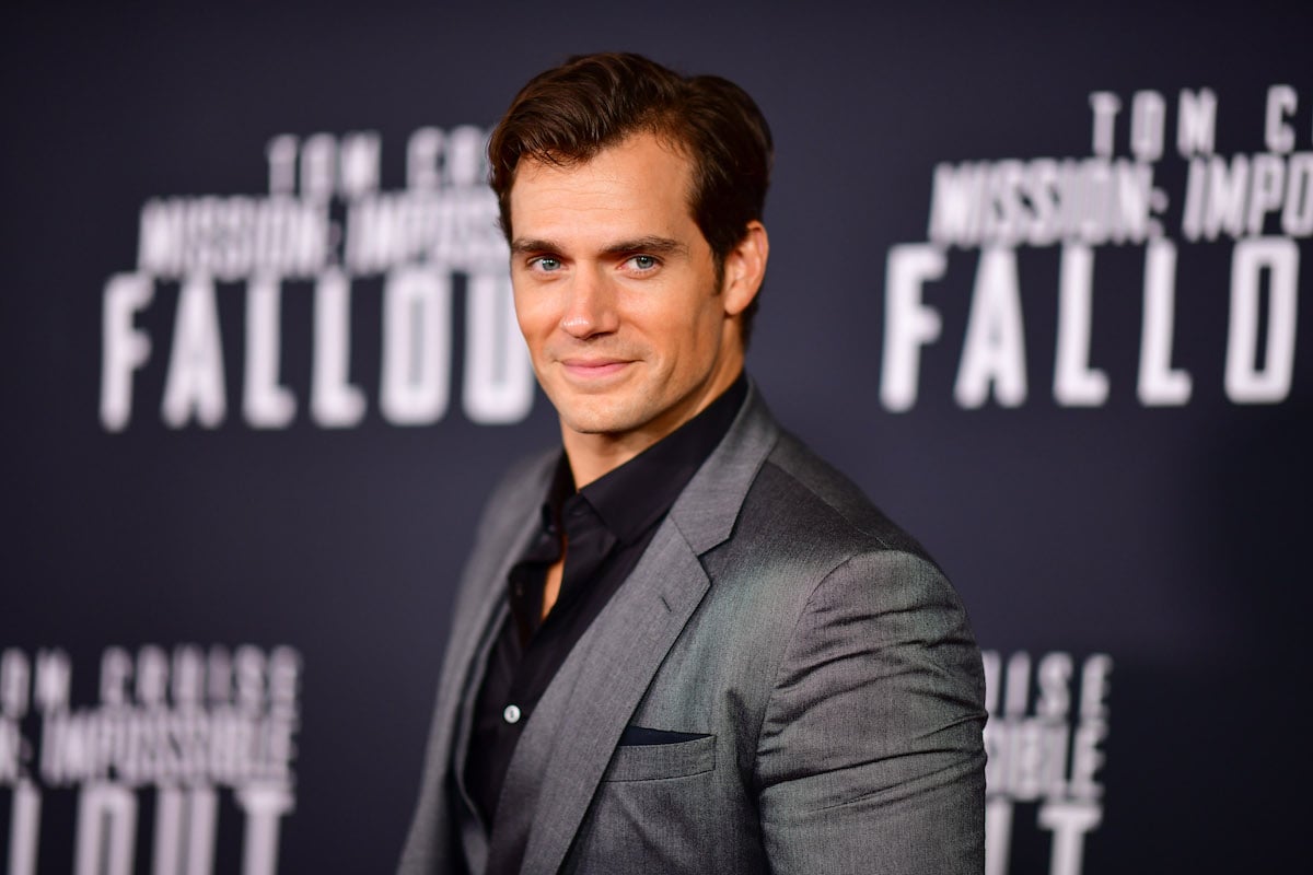 Henry Cavill smiling in front of a black background