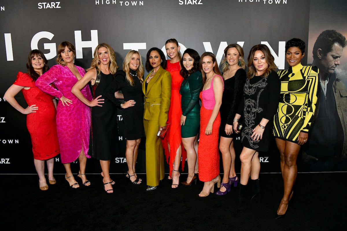 'Hightown' cast and crew members smiling in front of a black background