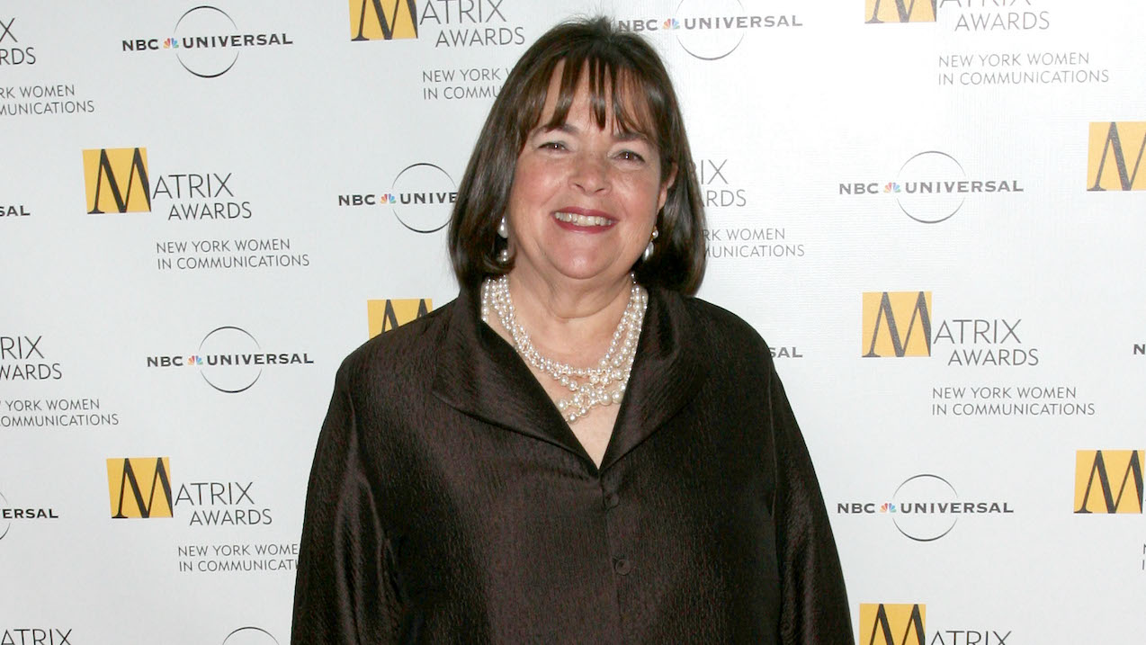 Ina Garten smiles for cameras wearing a black top and necklace