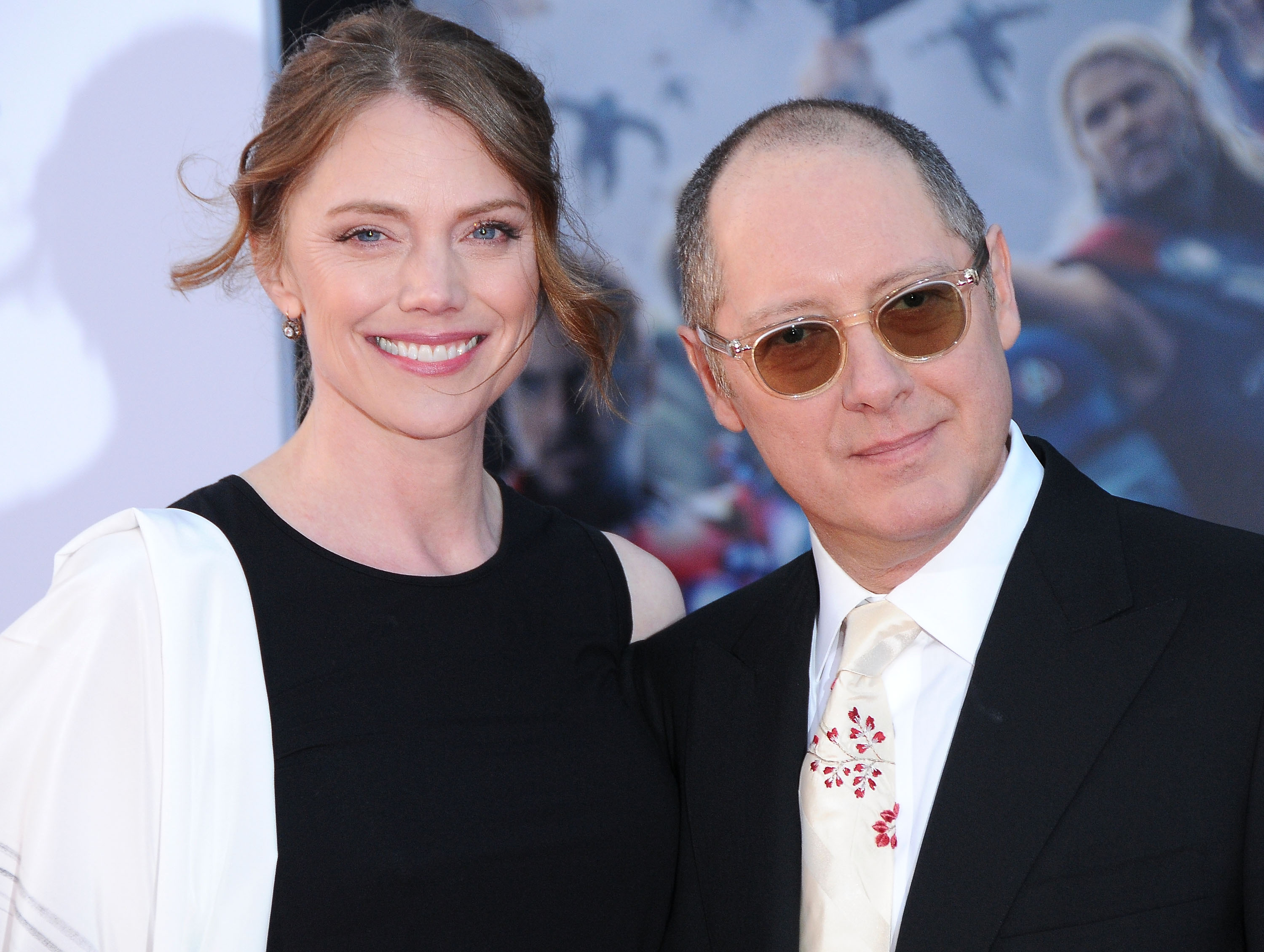 Leslie Stefanson and James Spader smile for a photo. Spader is wearing glasses.