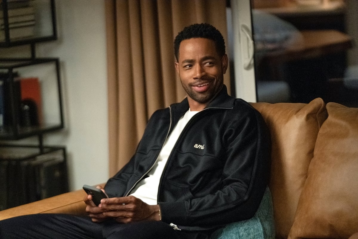 Jay Ellis sitting on a couch and texting on a cellphone in 'Insecure' Season 5.