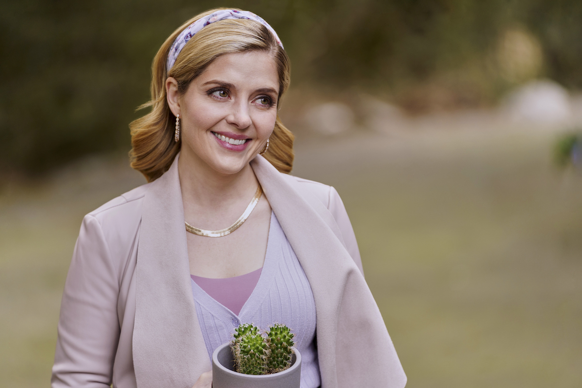 Jen Lilley smiling and holding a cactus in the Hallmark Channel movie 'Where Your Heart Belongs'
