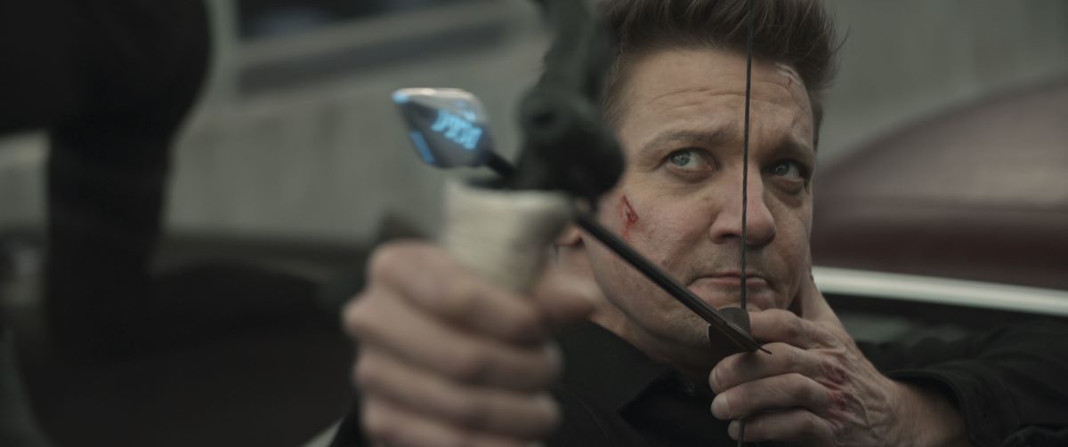 Jeremy Renner in a scene from the Hawkeye TV show pointing an arrow