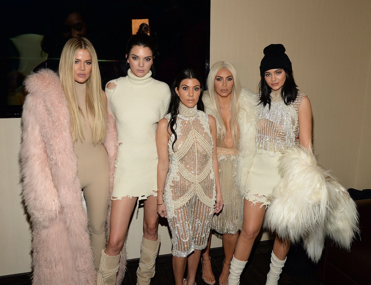 Kardashian-Jenner sisters in front of a tan background