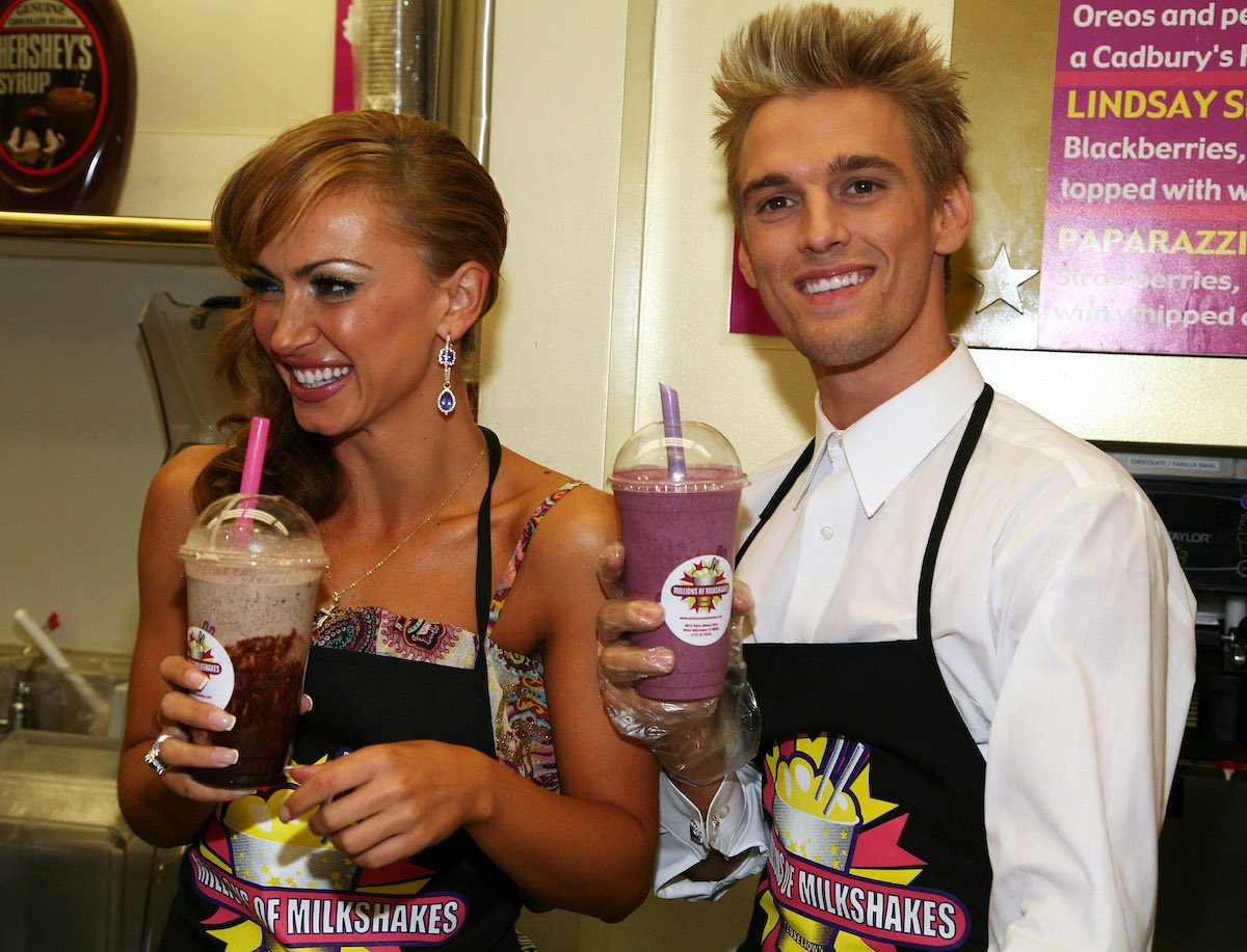 Karina Smirnoff and Aaron Carter smile and hold milkshakes.