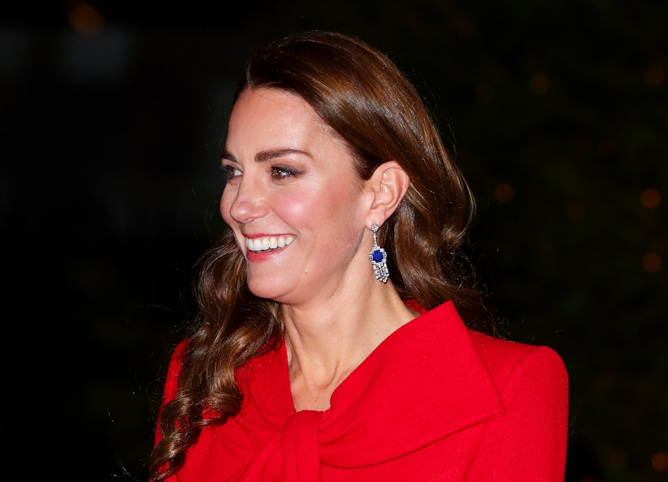 Kate Middleton wearing red, looking off-camera