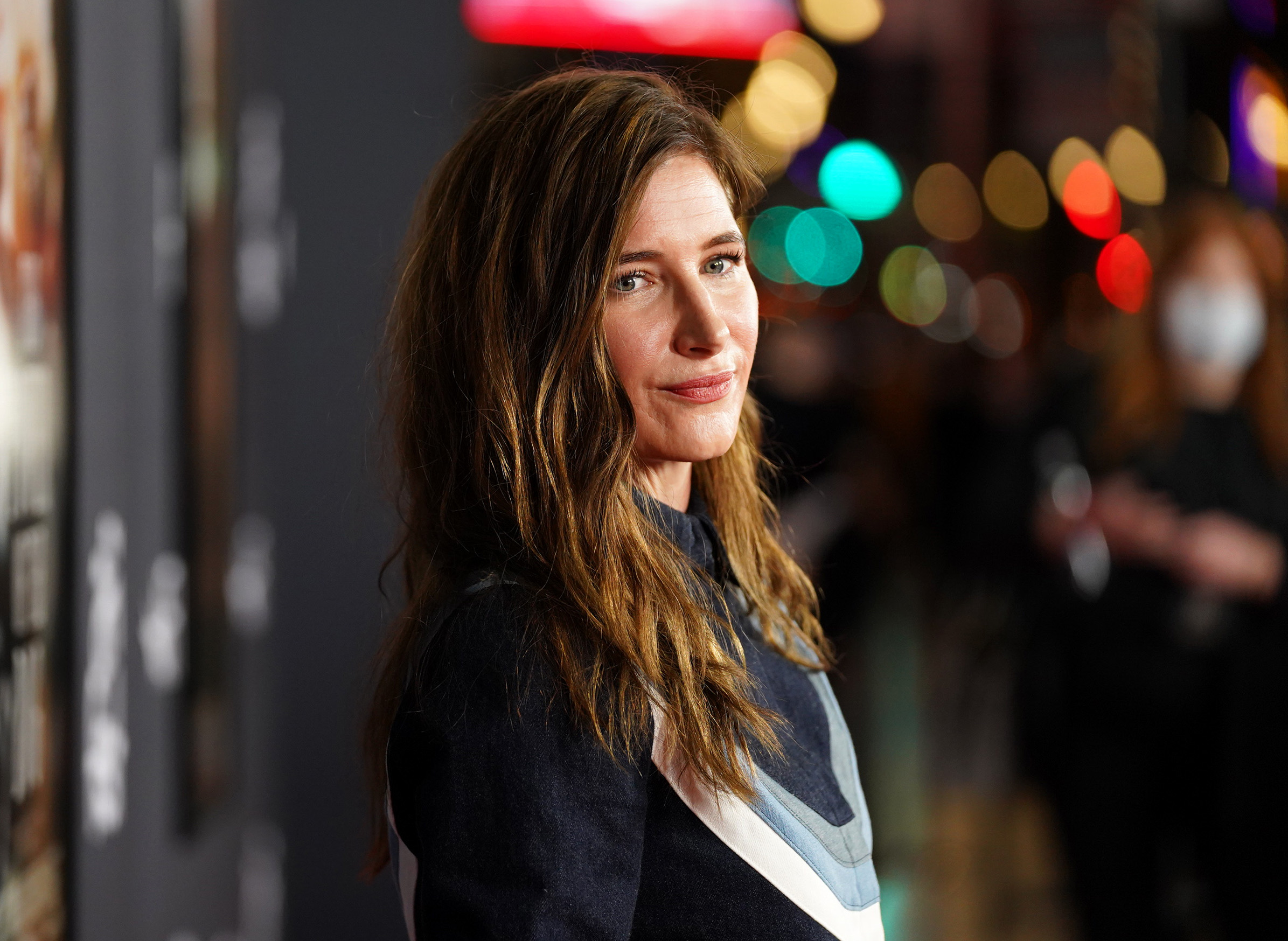 'WandaVision' star Kathryn Hahn wears a dark blue long-sleeved shirt with a white, light blue, and gray stripe going through it.