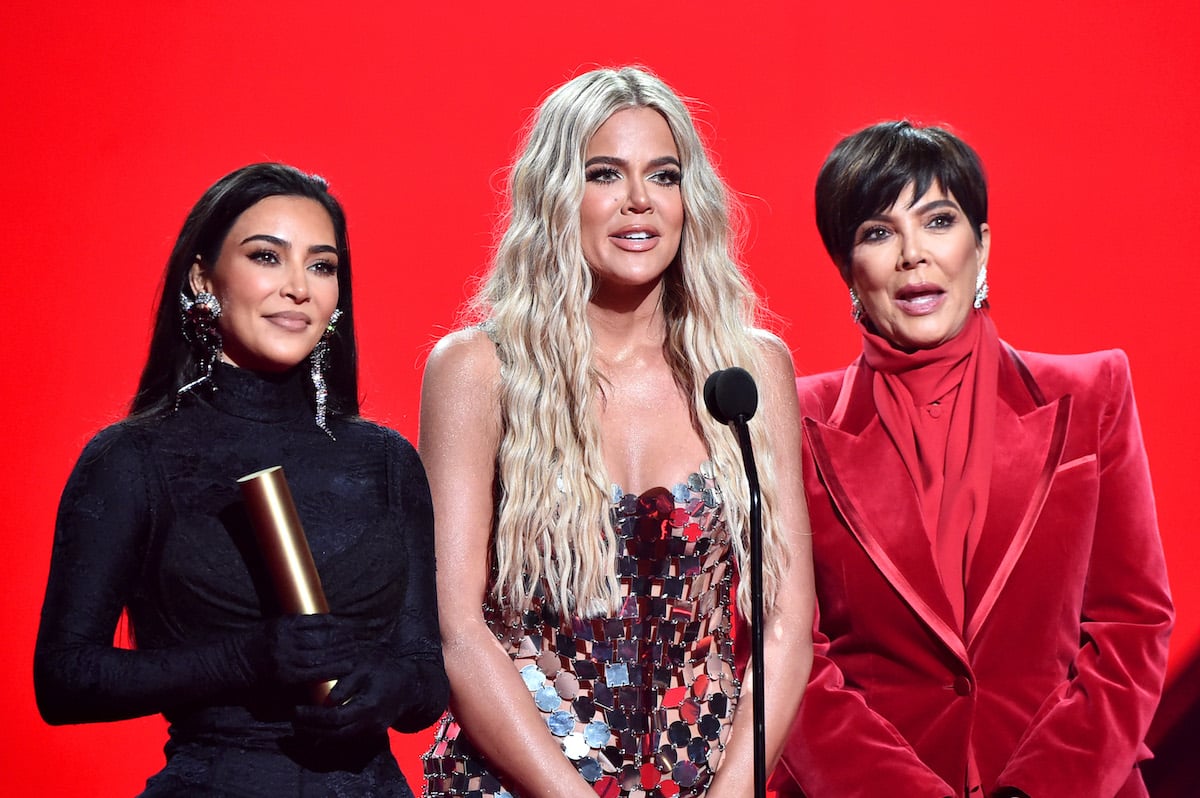 Kim Kardashian West, Khloe Kardashian, and Kris Jenner pose on stage together.
