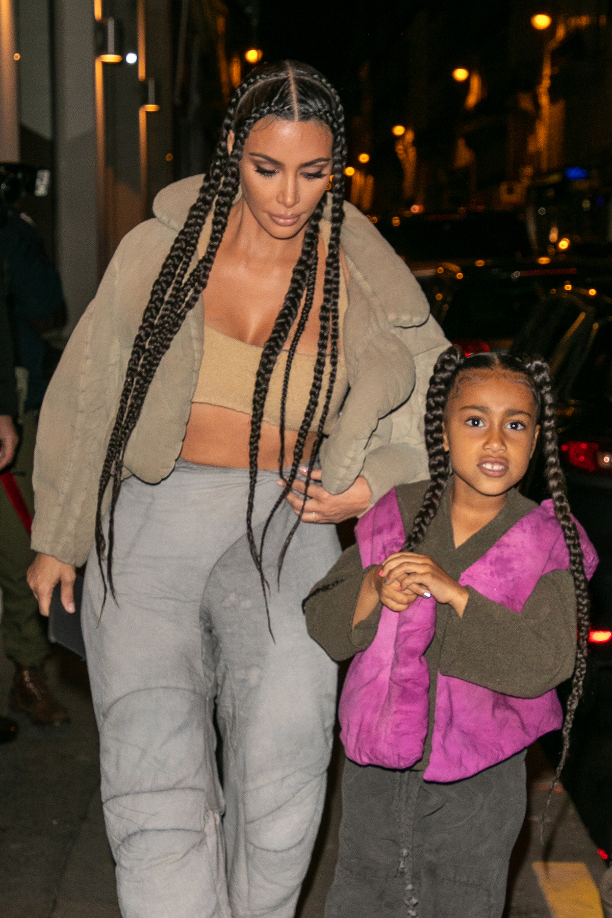Kim Kardashian West and North West walk together wearing matching braids.