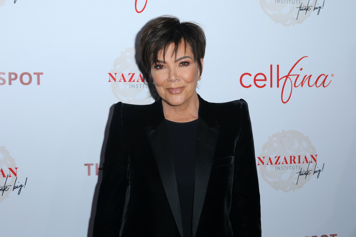 Kris Jenner smiling in front of a white background