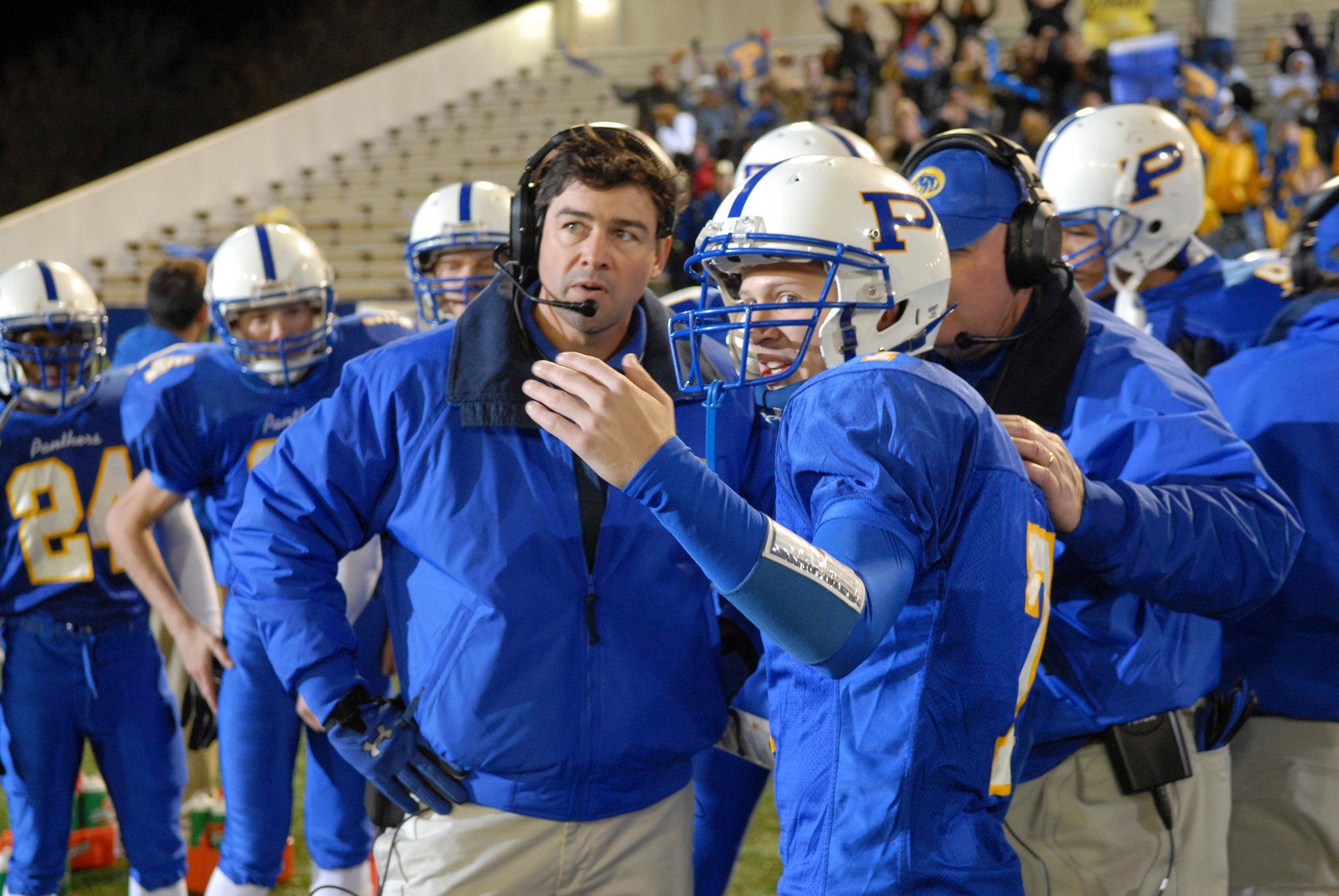 Kyle Chandler, and Zach Gilford wearing blue football attire in NBC's 'Friday Night Lights.'