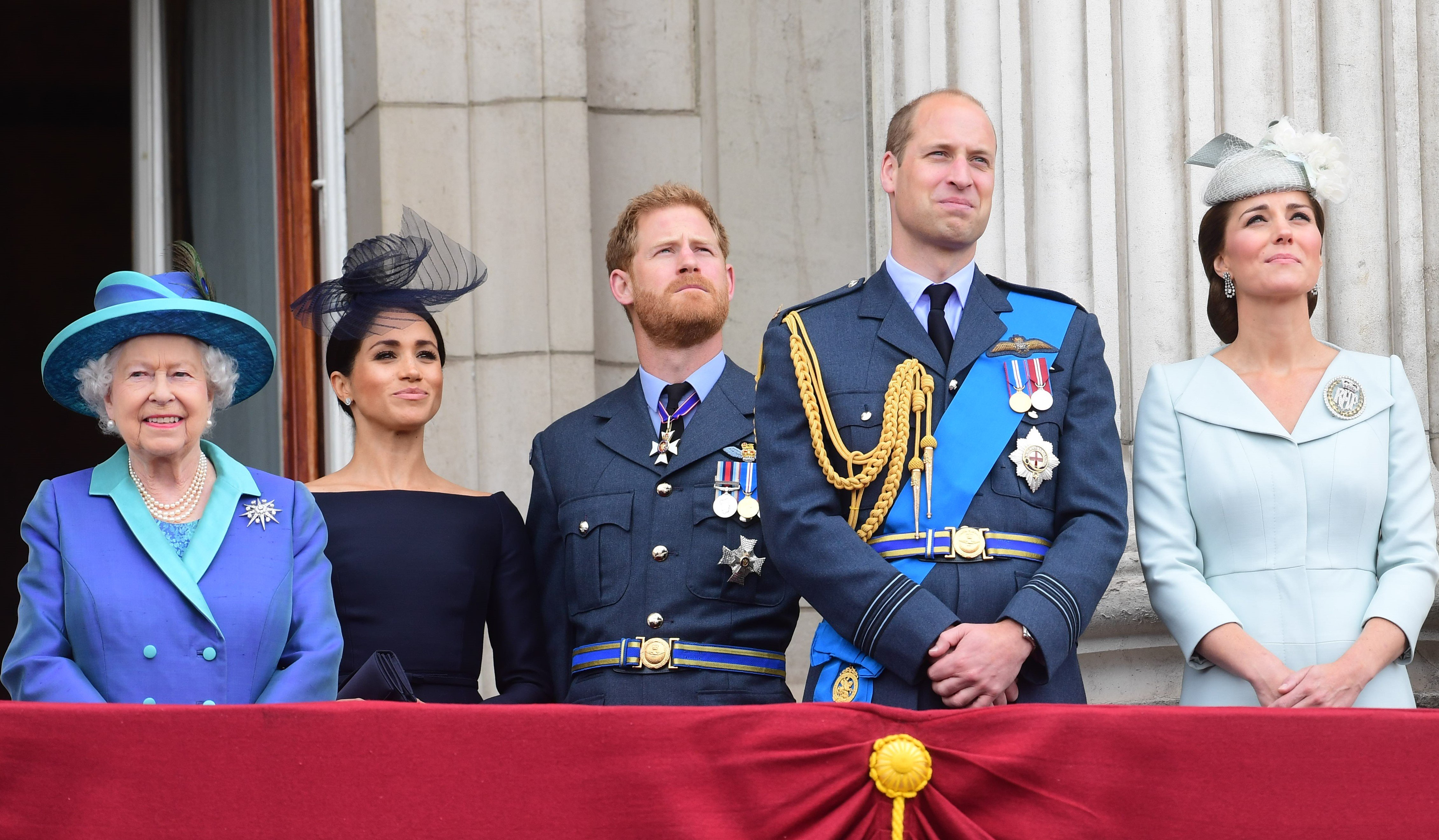 (L to R): Queen Elizabeth II, Meghan Markle, Prince Harry, Prince William, and Kate Middleton watching a flypast on the royal balcony