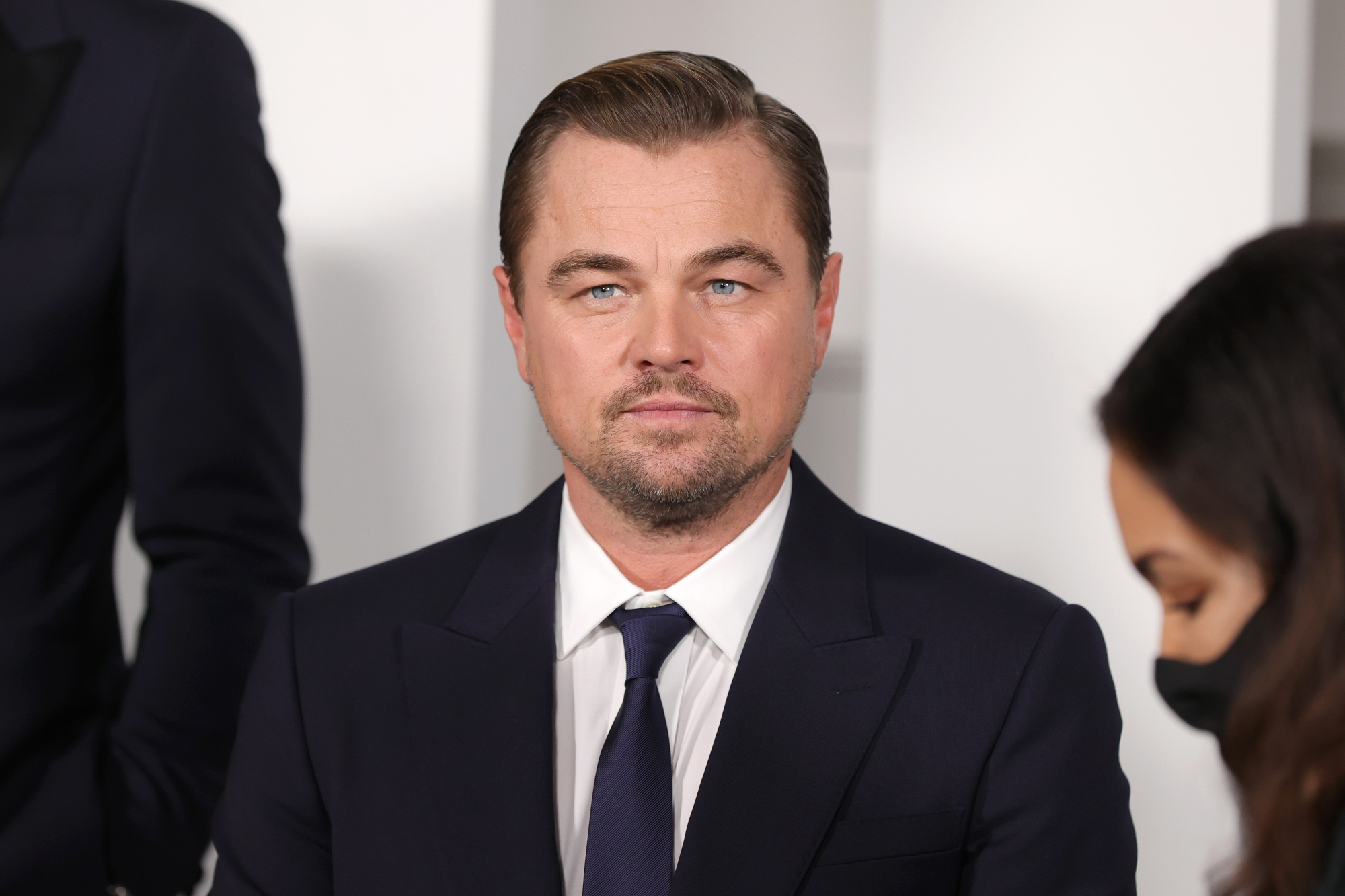 Leonardo DiCaprio featured image in article about his dad's 'Licorice Pizza' cameo in a suit