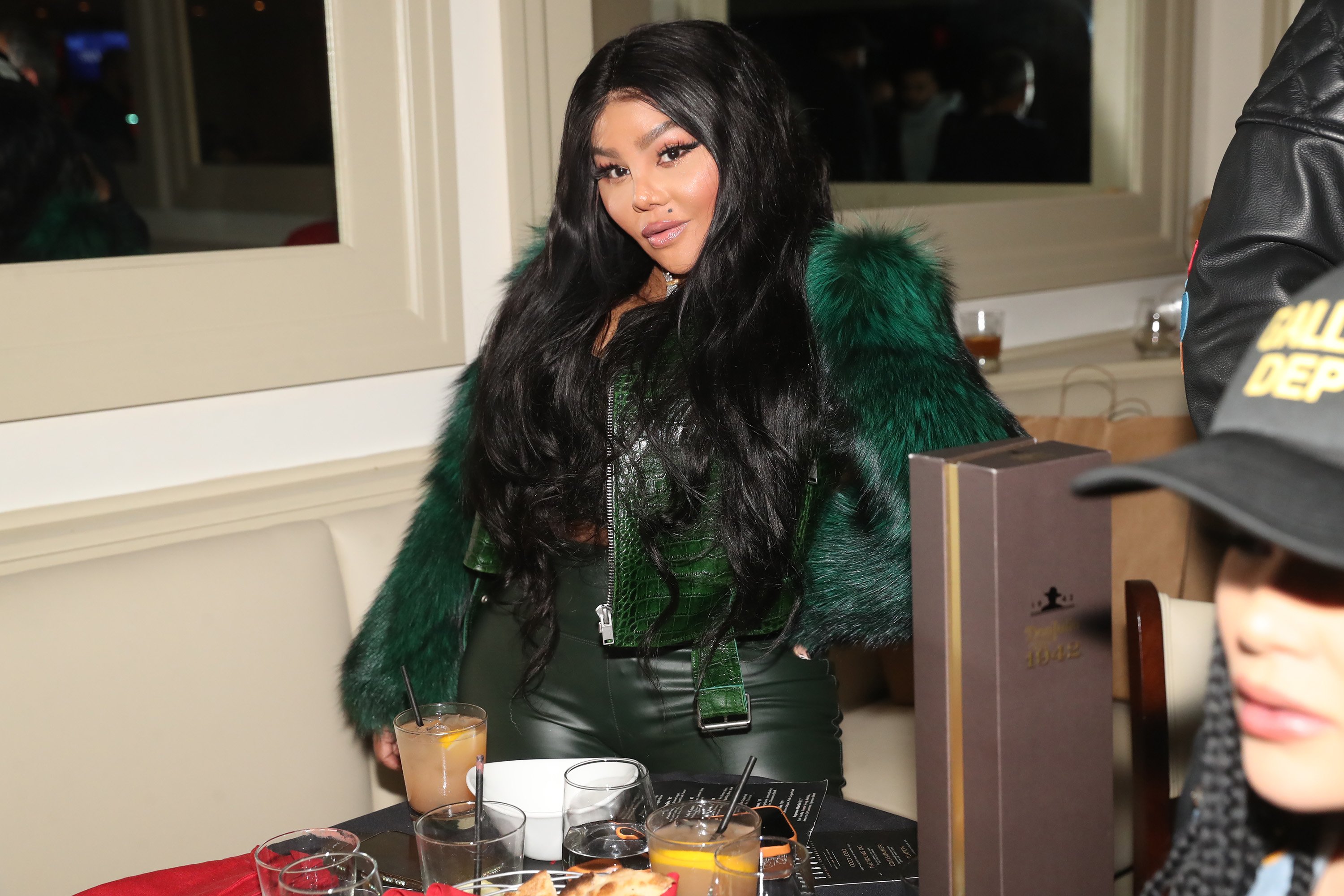 Lil Kim wearing a green fur at Fabolous' birthday dinner in NYC