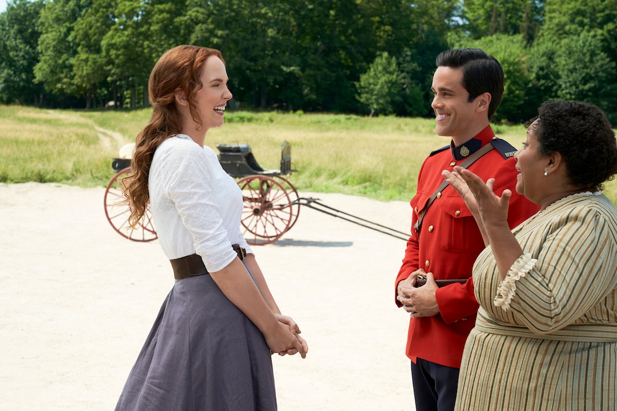 Lillian, Gabriel, and Pearl standing in a circle and laughing and smiling