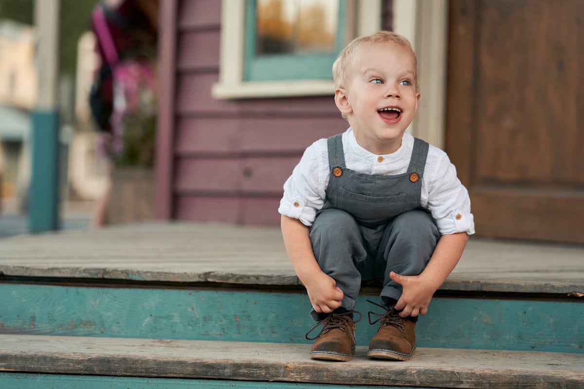 Smiling little Jack sitting on a step in 'When Calls the Heart' Season 8