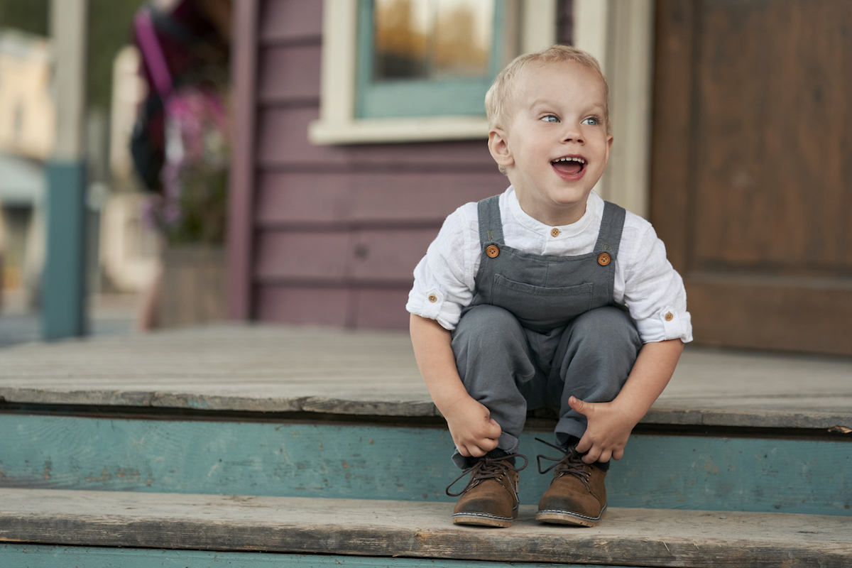 Smiling little Jack sitting on a step in 'When Calls the Heart' Season 8
