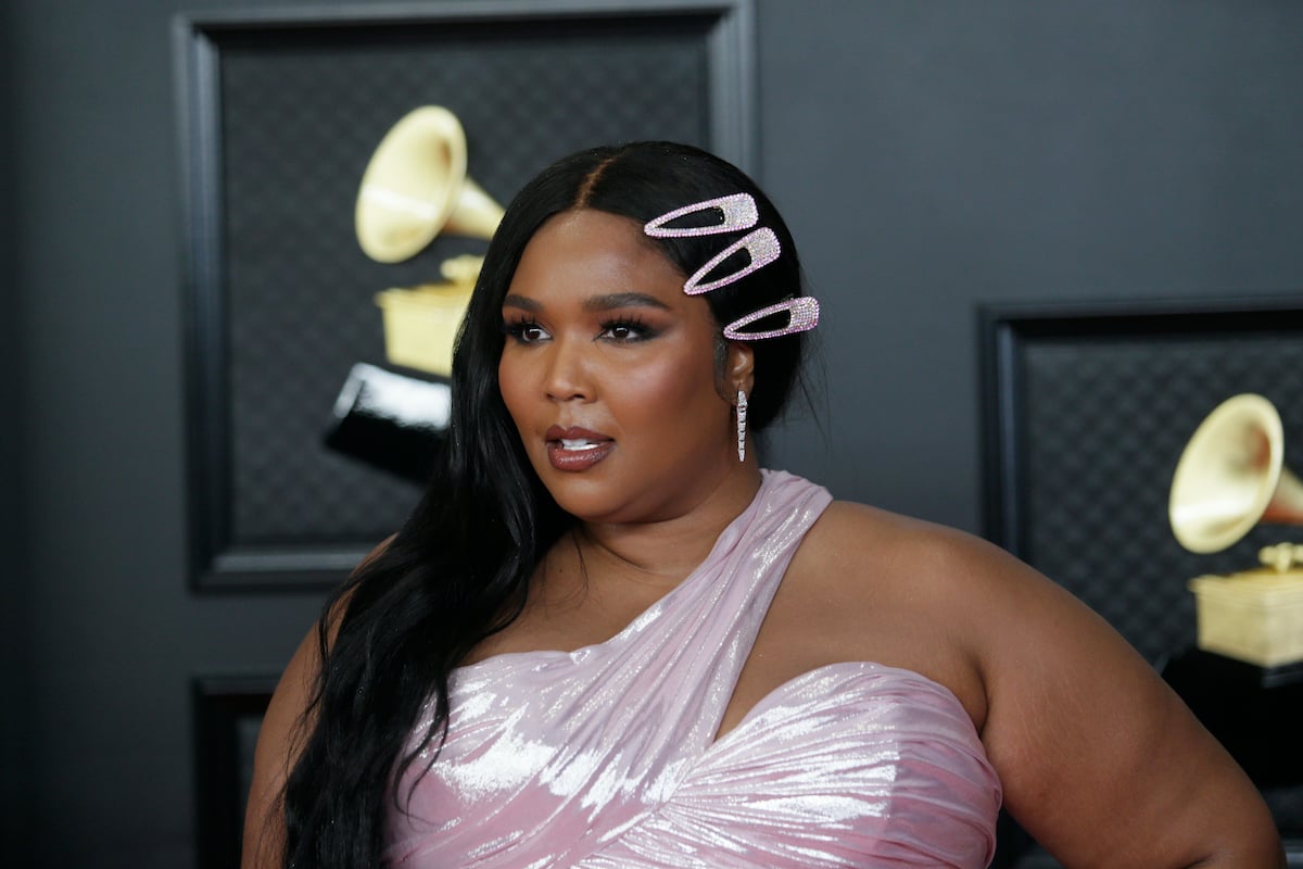 Lizzo standing in front of a black background