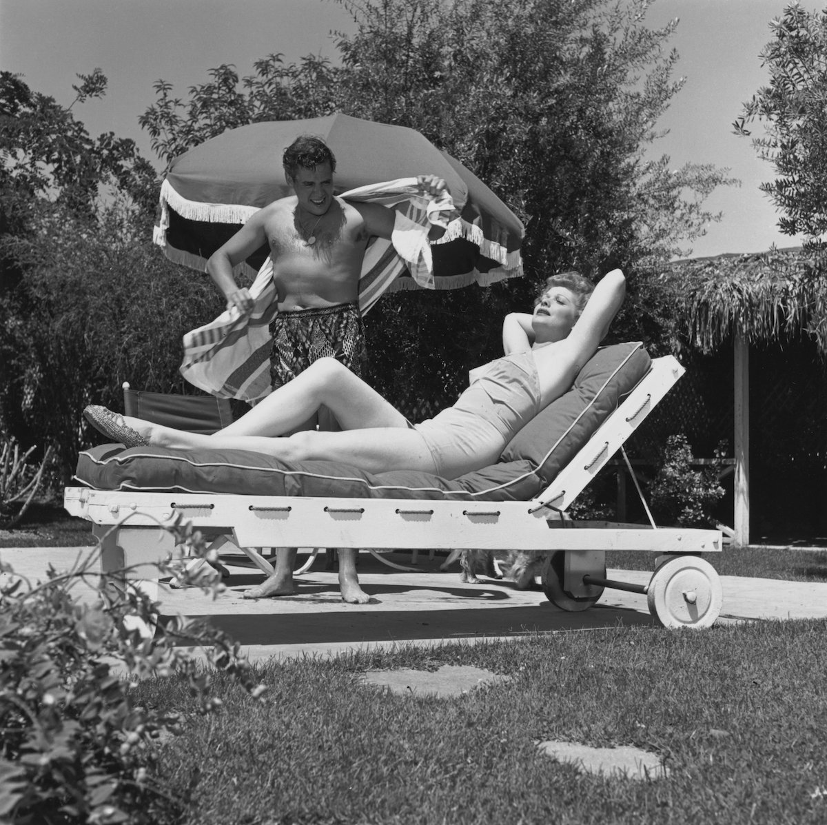 Lucille Ball and Desi Arnaz sun themselves in the garden of their home in 1955