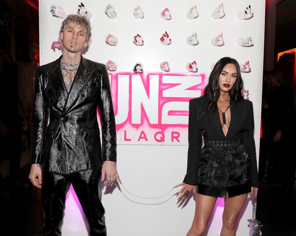 Machine Gun Kelly and Megan Fox chained together by their fingernails.