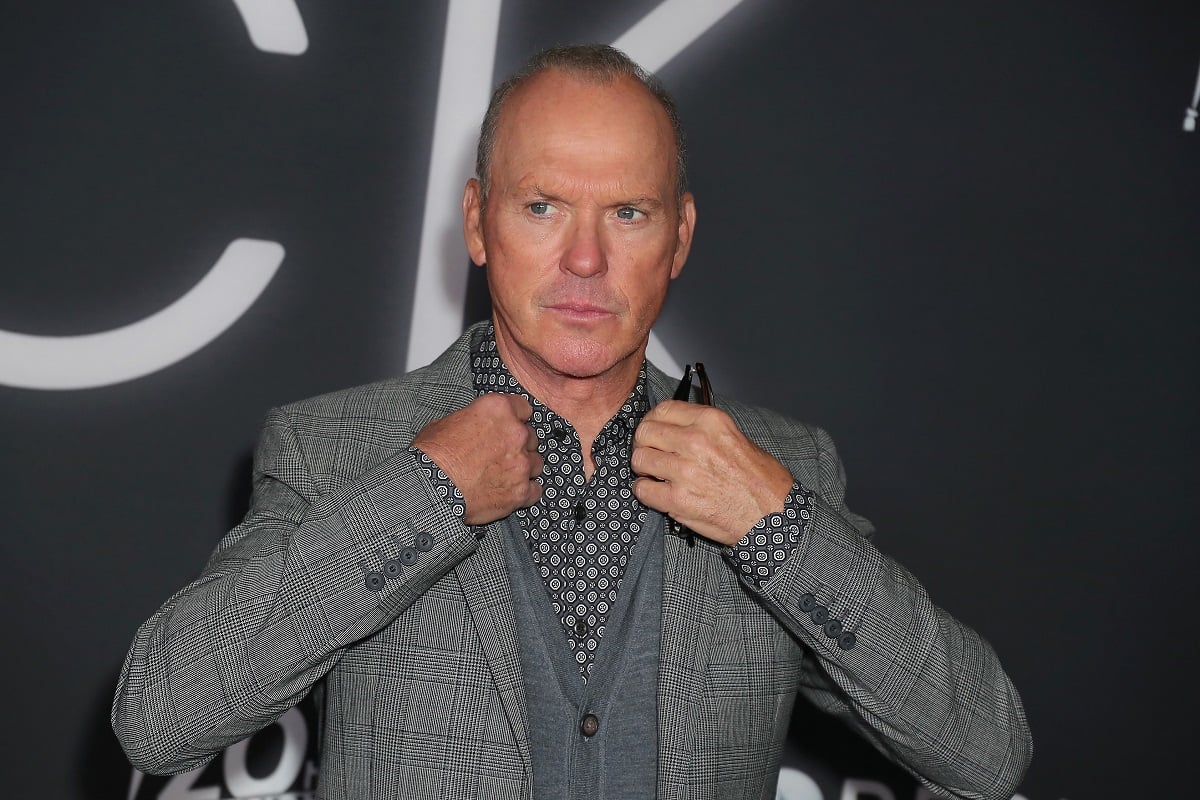 Michael Keaton posing in a gray suit.