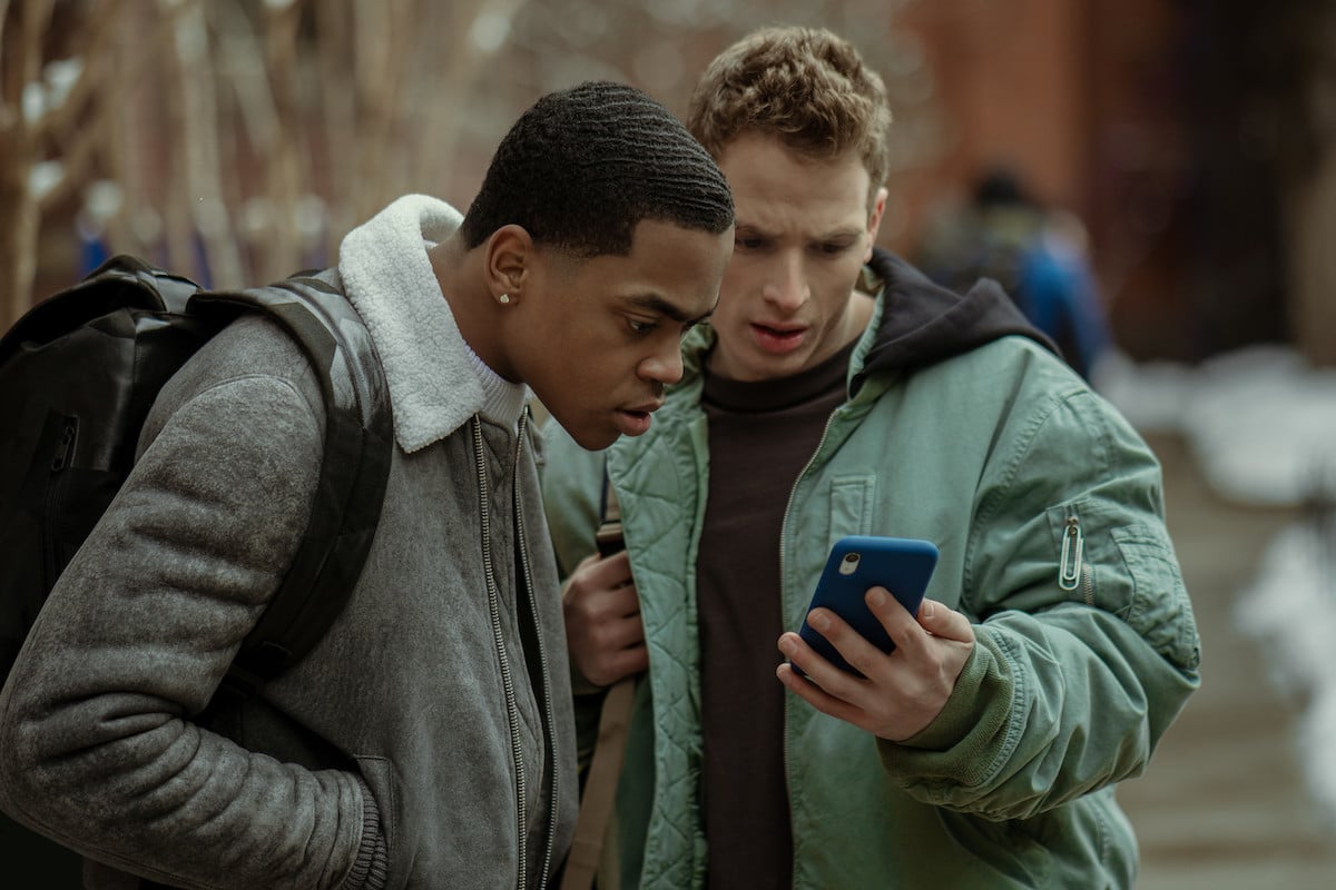 Michael Rainey Jr as Tariq St. Patrick and Gianni Paolo as Brayden Westen looking at a phone in 'Power Book II: Ghost'