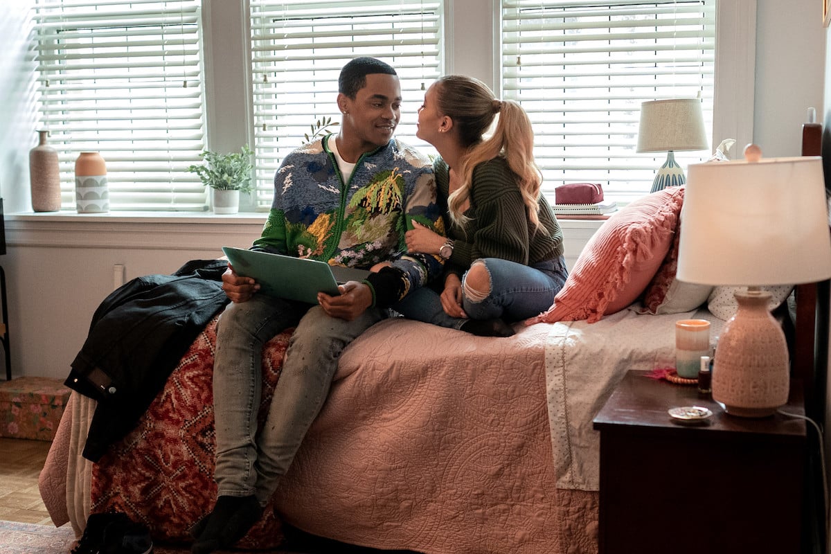 Michael Rainey Jr. as Tariq St. Patrick and Paige Hurd as Lauren Baldwin sitting on a bed smiling at one another in 'Power Book II: Ghost